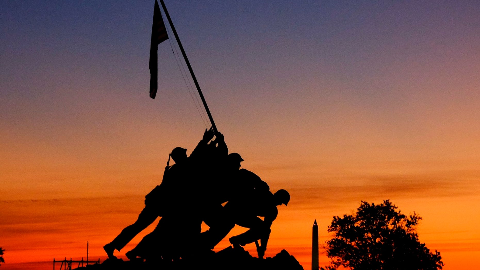 The rising sun turns the sky red and orange behind the U.S. Marine Corps War Memorial Friday, Nov. 3, 2017, in Arlington, Va. (AP Photo/J. David Ake)