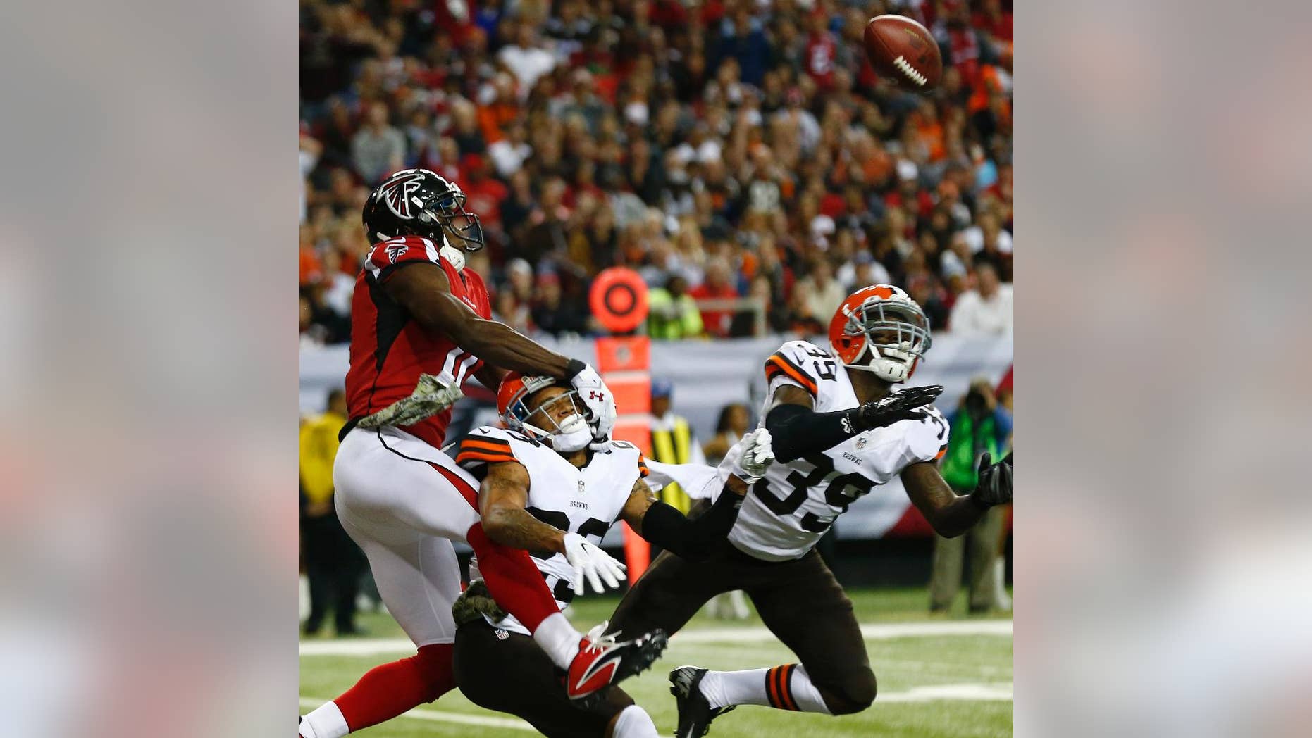 Atlanta Falcons wide receiver Julio Jones (11) vies for a passed ball as Cleveland Browns cornerback Joe Haden (23) and Cleveland Browns free safety Tashaun Gipson (39) defend during the second half of an NFL football game, Sunday, Nov. 23, 2014, in Atlanta. Cleveland Browns cornerback Joe Haden was called for holding and Cleveland Browns free safety Tashaun Gipson was injured and taken from the the field (AP Photo/John Bazemore)