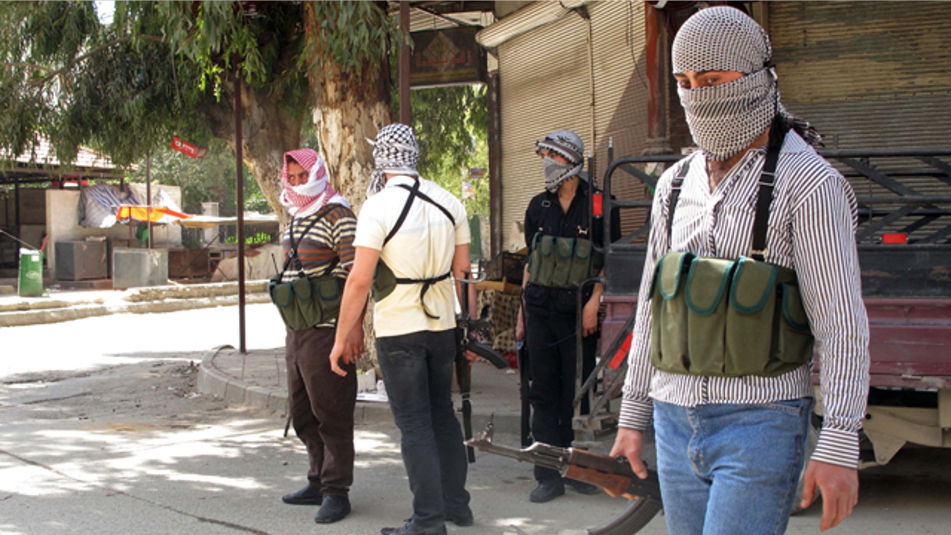 April 6: Free Syrian Army fighters gather on a corner during fighting with Syrian troops in a suburb of Damascus, Syria.