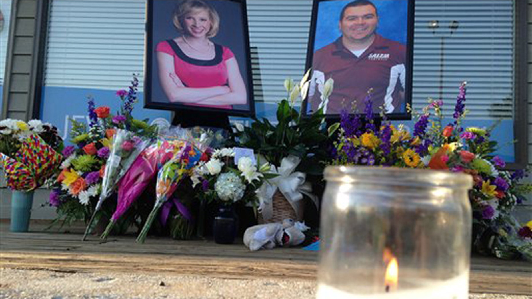 Aug. 28, 2015: A candle burns in front of a memorial for two slain journalists at Bridgewater Plaza in Moneta, Va.. The shopping center where the two were killed during a live television broadcast was reopening Friday for the first time since the shootings.