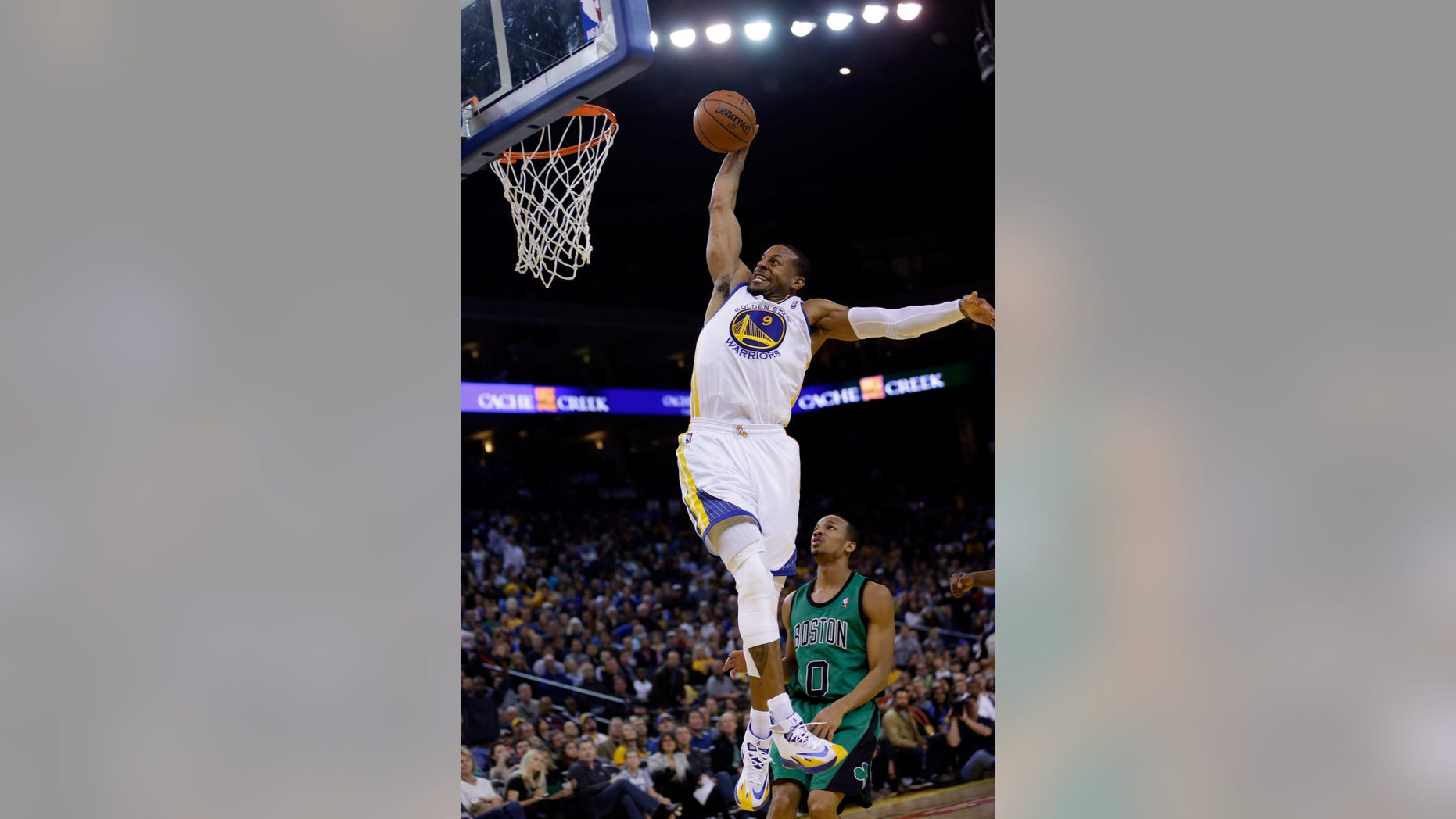Golden State Warriors' Andre Iguodala (9) goes up for a dunk next to Boston Celtics' Avery Bradley (0) during the second half of an NBA basketball game on Friday, Jan. 10, 2014, in Oakland, Calif. Golden State won 99-97. (AP Photo/Marcio Jose Sanchez)