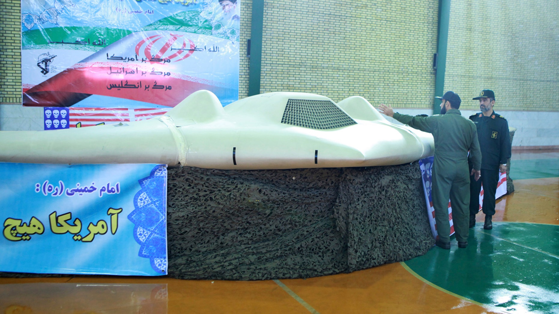 Dec. 8, 2011: This file photo released by the Iranian Revolutionary Guards, claims to show US RQ-170 Sentinel drone which Tehran says its forces downed earlier this week, as the chief of the aerospace division of Iran'ss Revolutionary Guards, Gen. Amir Ali Hajizadeh, right, listens to an unidentified colonel, in an undisclosed location, Iran.