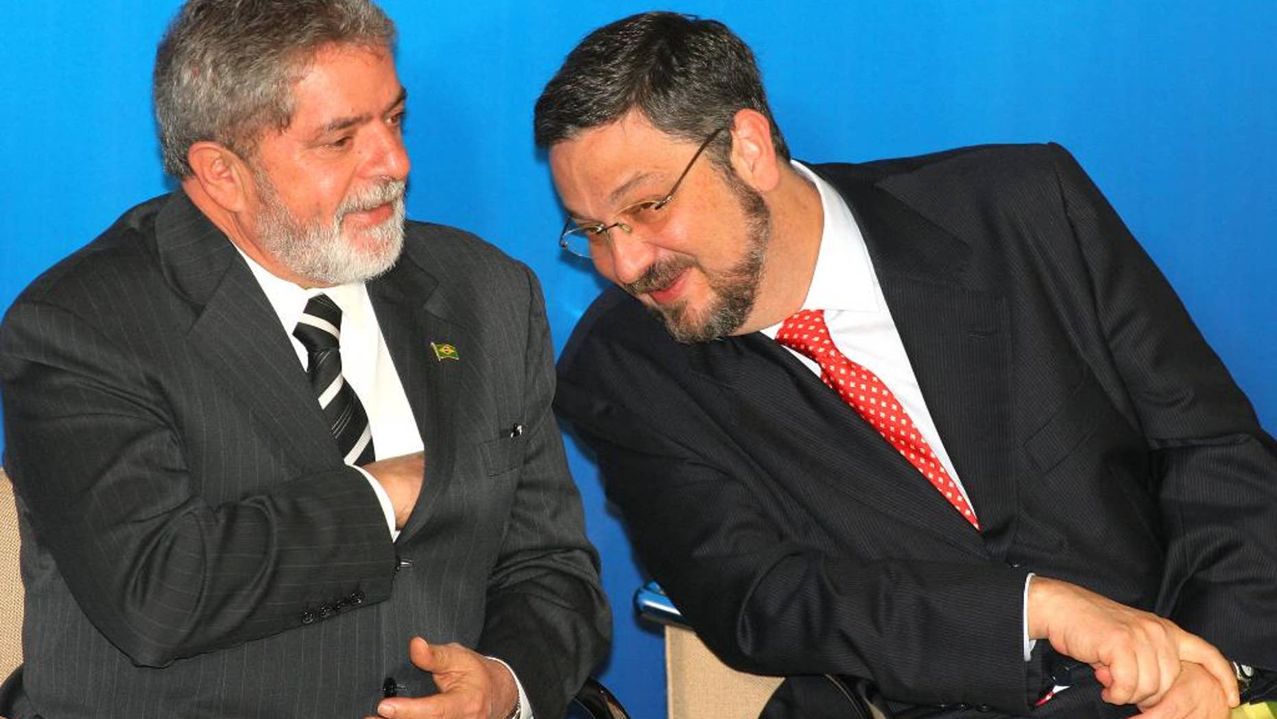 FILE - In this June 15, 2005 file photo, Brazil's President Luiz Inacio Lula da Silva, left, speaks with his Economy Minister Antonio Palocci during a ceremony at the presidential palace in Brasilia, Brazil. Palocci was arrested, police said on Monday, Sept. 26, 2016, the latest detention in connection with a wide-ranging investigation into a kickback scheme in state oil company Petrobras. This month investigators charged Lula with money laundering and corruption. (AP Photo/Eraldo Peres, File)
