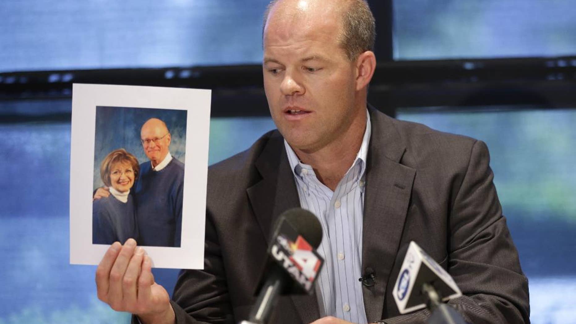 FILE - In this Aug. 14, 2014, file photo, attorney Paxton Guymon holds a photograph of Jim and Jan Harding during a news conference in Salt Lake City. Jan Harding, 67, who nearly died after unknowingly drinking iced tea mixed with chemicals has been released from a Salt Lake City hospital. Harding has been slowly improving since Aug. 10, when she drank a single sip of sweetened iced tea at Dickey's Barbecue in South Jordan, a Salt Lake City suburb. (AP Photo/Rick Bowmer, File)