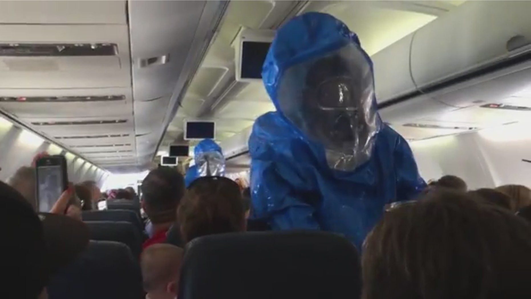 Emergency responders in hazmat suits on US Airways flight 845 from Philadelphia to Dominican Republic after a passenger caused a health scare.