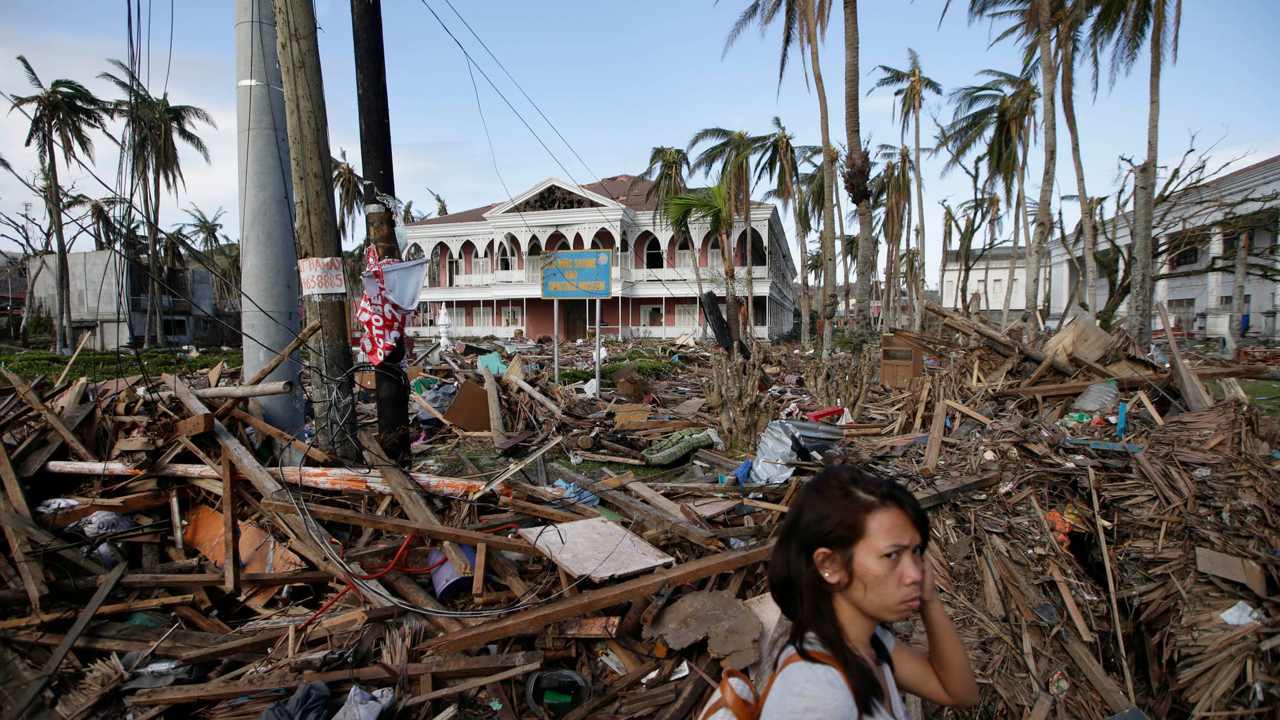 A typhoon survivor walks past the debris-littered Sto. Nino Shrine and Heritage Museum which used to house former Philippine First Lady Imelda Marcos' collection of art pieces from Philippine national artists Sunday Nov. 17, 2013 at Tacloban city, Leyte province in central Philippines. Typhoon Haiyan, one of the most powerful typhoons ever recorded, slammed into central Philippine provinces Nov.8, leaving a wide swath of destruction and thousands of people dead.(AP Photo/Bullit Marquez)
