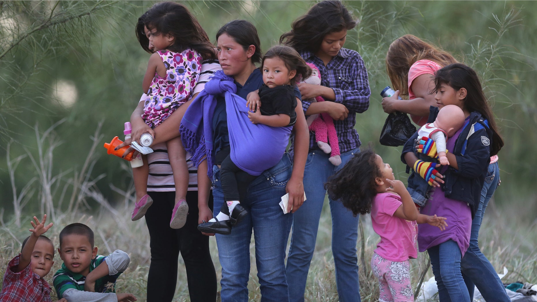 MISSION, TX - JULY 24: Central American immigrants await transportation to a U.S. Border Patrol processing center after crossing the Rio Grande from Mexico into the Texas on July 24, 2014 near Mission, Texas. Tens of thousands of undocumented immigrants, many of them families or unaccompanied minors, have crossed illegally into the United States this year and presented themselves to federal agents, causing a humanitarian crisis on the U.S.-Mexico border. The Rio Grande Sector of the border has the heaviest traffic of illegal crossings of the entire U.S.-Mexico border. (Photo by John Moore/Getty Images)