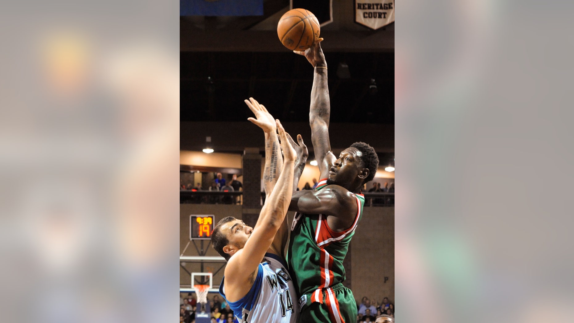 Milwaukee Bucks center Larry Sanders (8) takes a shot over Minnesota Timberwolves center Nikola Pekovic (14) during an NBA preseason basketball game in Sioux Falls, S.D., Thursday, Oct. 10, 2013. (AP Photo/Dave Weaver)