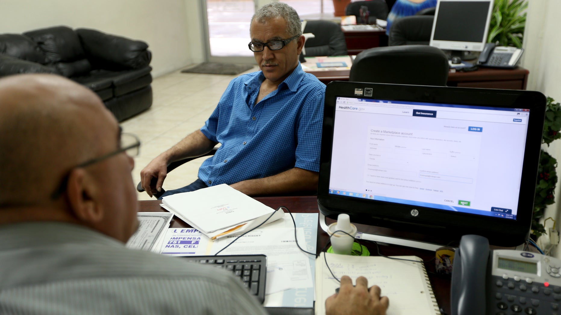 MIAMI, FL - FEBRUARY 13: Hisham Uadadeh (R) enrolls in a health insurance plan under the Affordable Care Act with the help of A. Michael Khoury at Leading Insurance Agency on February 13, 2014 in Miami, Florida. Numbers released by the government showed that about 3.3 million people signed up for health insurance plans under the Affordable Care Act through the end of January. (Photo by Joe Raedle/Getty Images)