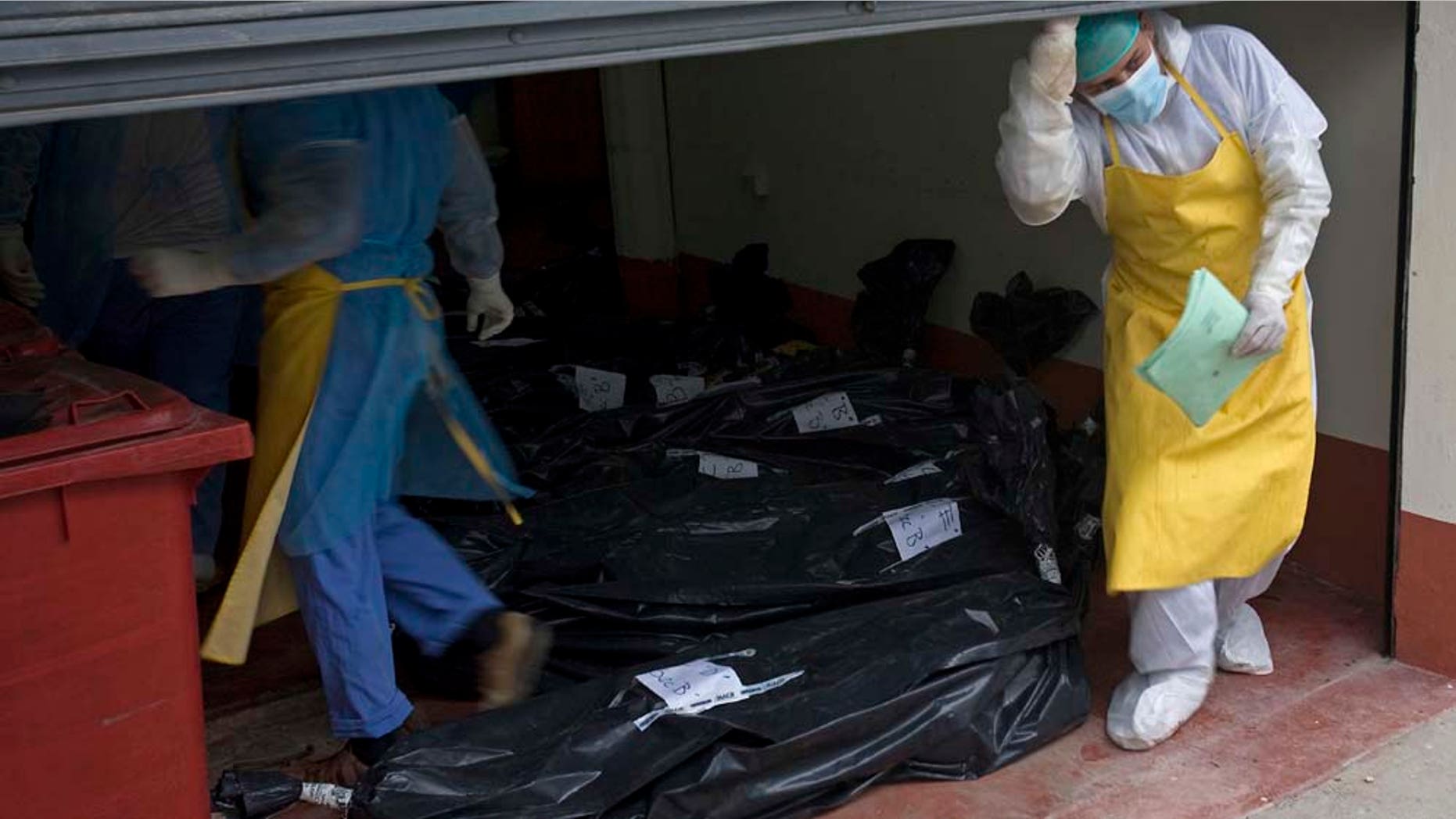 Morgue employees take in the bodies that were found on a ranch in northern Guatemala, at the local morgue in San Benito, Guatemala, Monday, May 16, 2011. Initial reports said assailants killed Sunday at least 29 people, but Monday the death toll confirmed decreased to 27 persons. Guatemalan authorities on Monday blamed the massacre on the Mexican drug cartel the Zetas. (AP Photo/Moises Castillo)