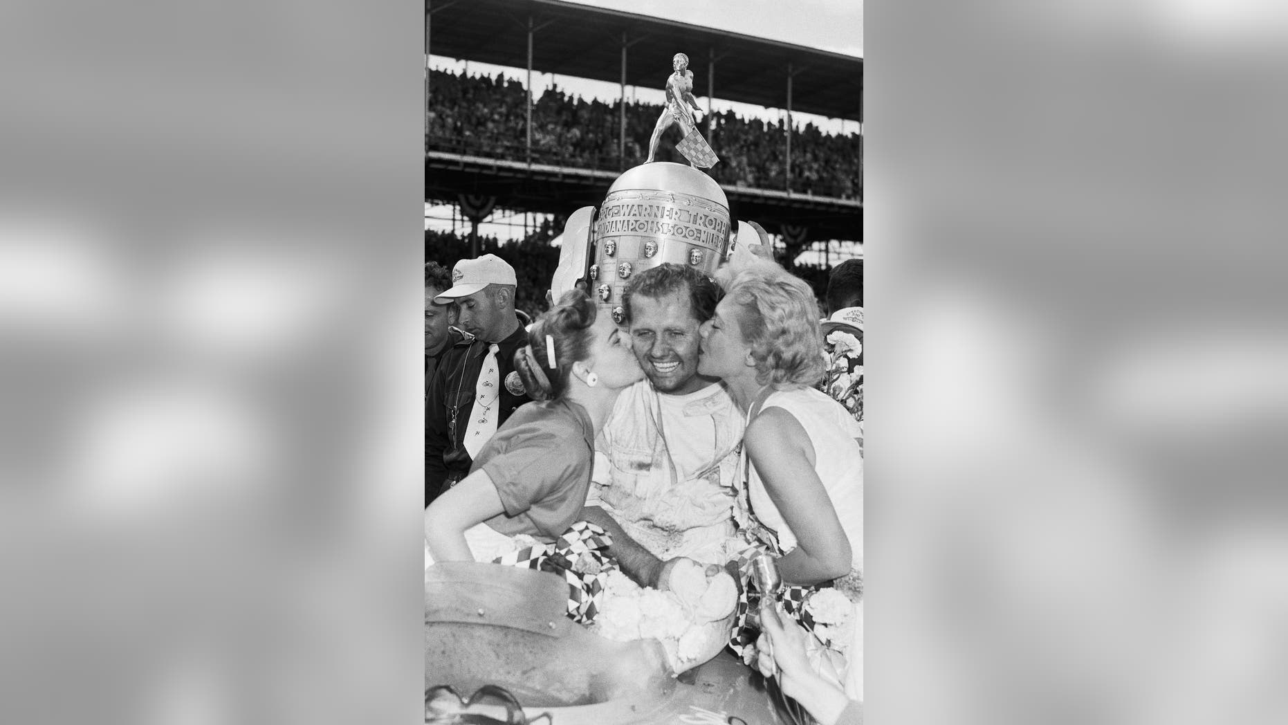 FILE - In this May 30, 1955, file photo, Bob Sweikert receives kisses from his wife, Dolores, left, and singer Dinah Shore after winning the 39th Indianapolis 500 auto race at Indianapolis Motor Speedway in Indianapolis, Ind. (AP Photo/File)