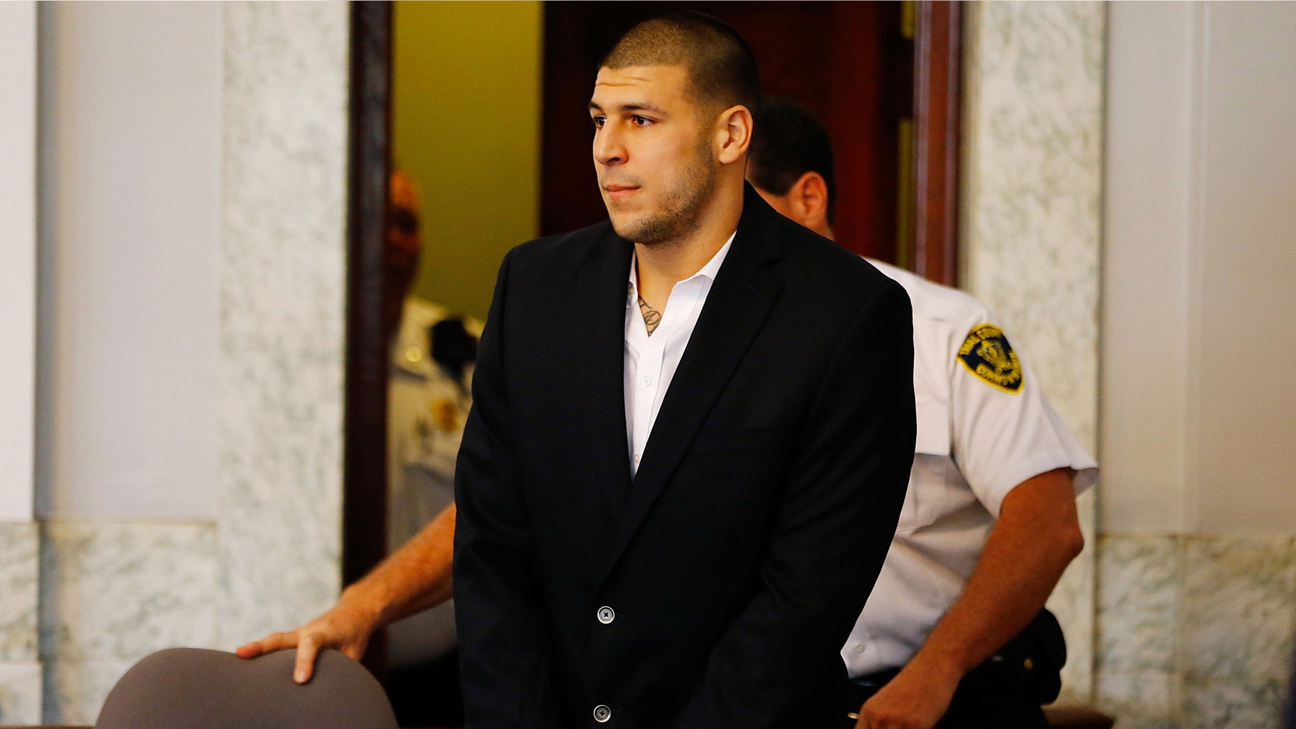 Aaron Hernandez is escorted into the courtroom on August 22, 2013 in North Attleboro, Massachusetts.