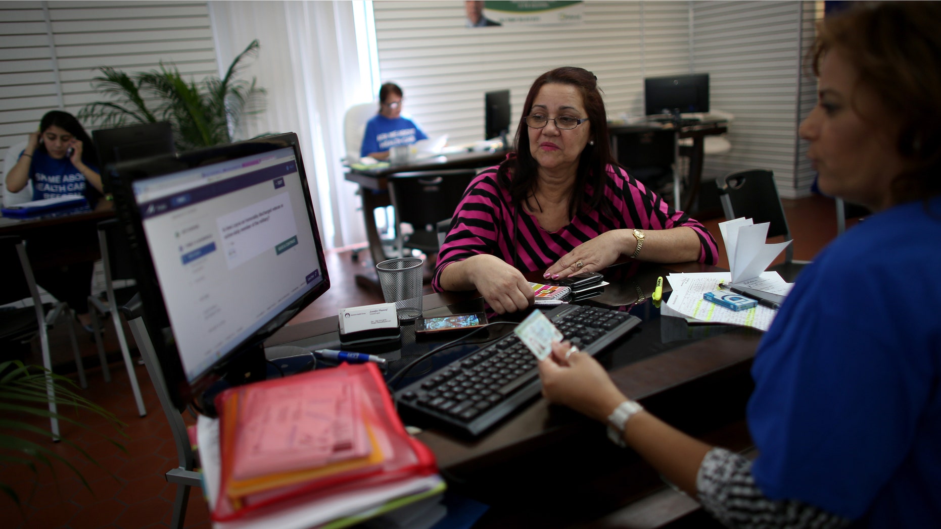 HIALEAH, FL - NOVEMBER 14: Ines Leyva works with Marlene Portuondo, an insurance agent with Sunshine Life and Health Advisors, as she looks to purchase an insurance policy under the Affordable Care Act at the store setup in the Westland Mall on November 14, 2013 in Hialeah, Florida. As the insurance agents continue to help people purchase and understand the policies offered under the Affordable Care Act, U.S. President Barack Obama announced that Americans who have had their health insurance plans canceled because of the Affordable Care Act can keep those plans for another year if they wish to. (Photo by Joe Raedle/Getty Images)