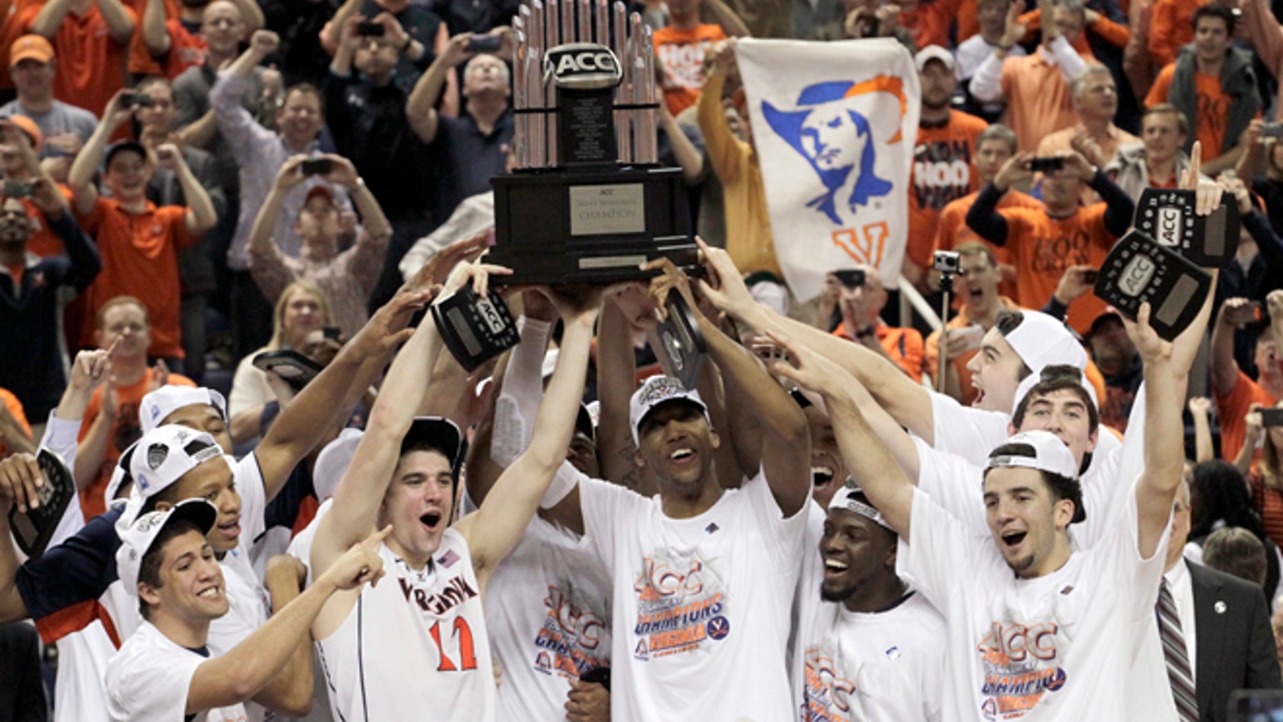 Virginia players celebrate with the trophy after defeating Duke in an NCAA college basketball game in the championship of the Atlantic Coast Conference tournament in Greensboro, N.C., Sunday, March 16, 2014. Virginia won 72-63. (AP Photo/Bob Leverone)