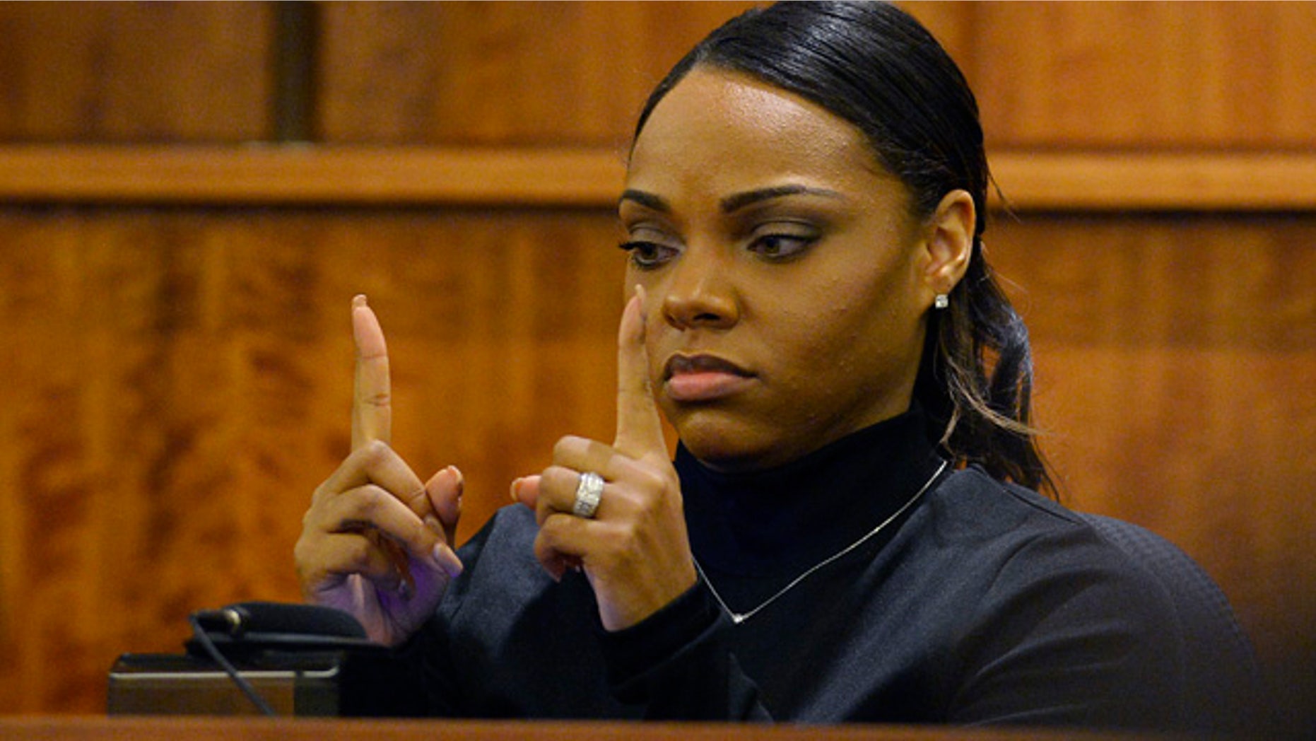 March 27, 2015: Shayanna Jenkins, fiancee of former New England Patriots football player Aaron Hernandez, shows the approximate size of a gun she saw in a kitchen drawer in the home where she and Hernandez lived, as she testifies during his murder trial in Fall River, Mass. (AP Photo/CJ Gunther, Pool)