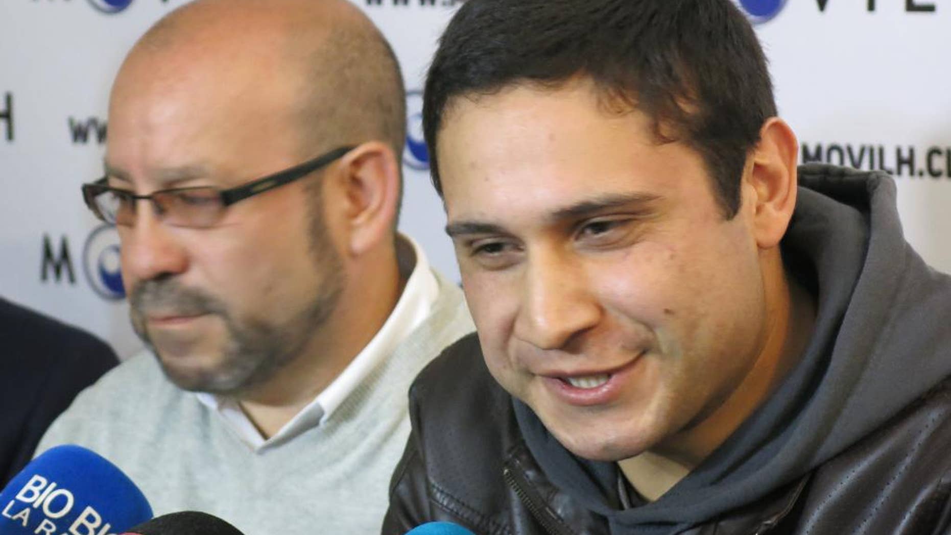 ADDS MONTH - Mauricio Ruiz, 24, sailor of the Chilean Navy, right, comes out publicly as gay during a press conference in Santiago, Chile, Wednesday Aug. 27, 2014. Ruiz who was accompanied by Rolando Jimenez, left, president of the Homosexual Liberation and Integration Movement, is the first member of the Chilean armed forces ever to come out publicly as gay with the approval of the High Command of the Chilean navy. (AP Photo/Eva Vergara)