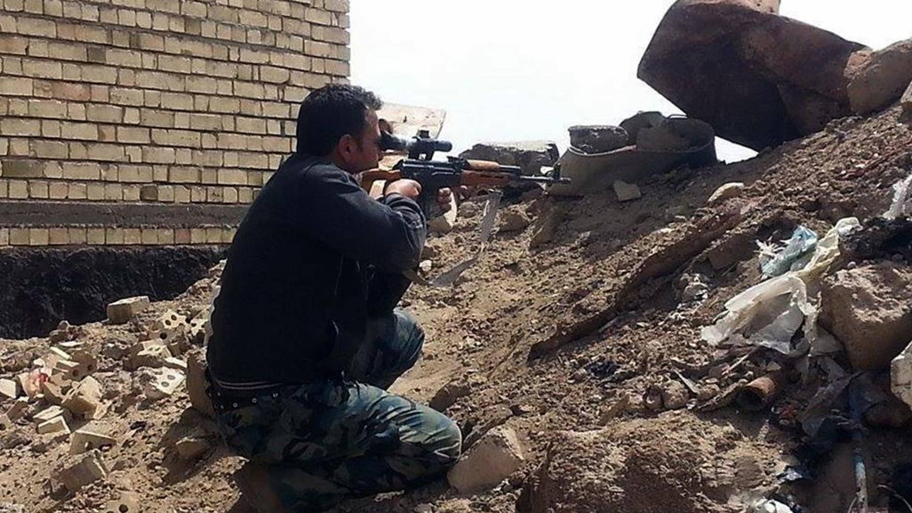 CLARIFYING IDENTITY OF MAN. A member of the Iraqi security forces aims his weapon to attack Islamic State group militants on al-Houz bridge on the Euphrates river in Ramadi, 70 miles (115 kilometers) west of Baghdad, Iraq, Friday, April 24, 2015. Iraqi security forces recaptured a key bridge from Islamic militants in the capital of western Anbar on Friday, said an Iraqi security official, as top Shiite cleric renewed calls for national unity among political groups in the face of Islamic militant group. (AP Photo)