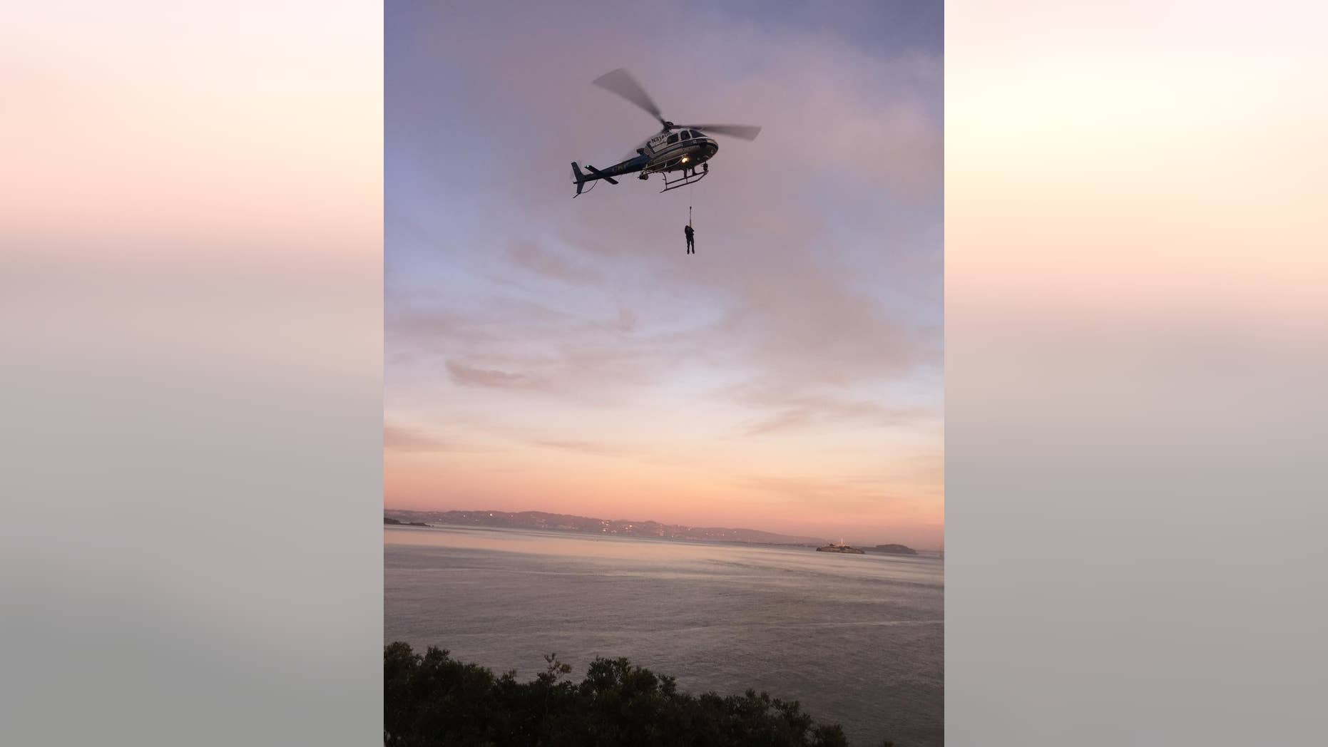 ADDS DAY AND DATE - In this photo provided by the National Park Service a California Highway Patrol helicopter lifts a suspect to safety during the rescue of two suspected vandals at Golden Gate National Recreation Area Thursday Feb. 26, 2015. Park service spokeswoman Alexandra Picavet says the men got stuck on a cliff at the waterfront of Fort Baker in Golden Gate National Recreation Area. She says they saw rangers approaching and tried to evade arrest by scrambling down a cliff near the water's edge. (AP Photo/U.S. National Park Service)