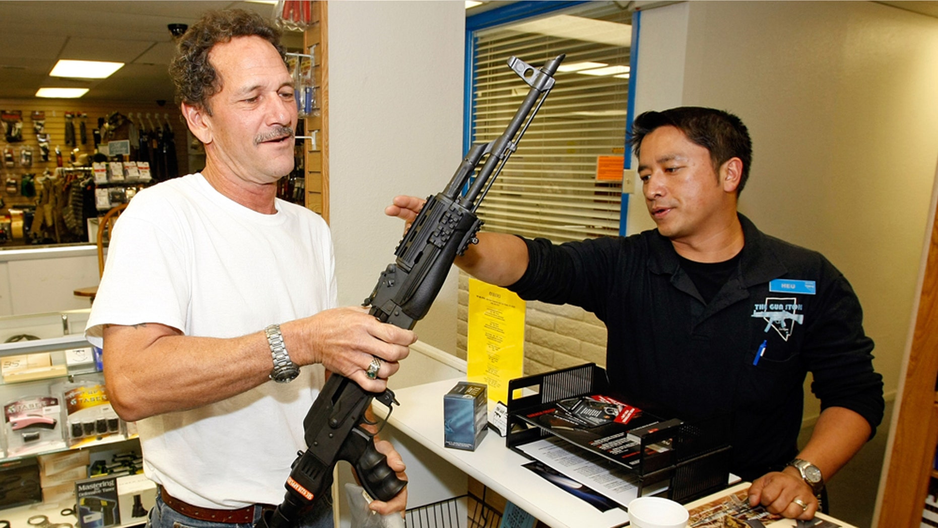 LAS VEGAS - NOVEMBER 14: The Gun Store rangemaster Heu Thao (R) shows Gregory Smith of Nevada the modifications made to his AK-47 assault rifle November 14, 2008 in Las Vegas, Nevada. Store manager Cliff Wilson said he's seen a large spike in sales since Barack Obama was elected president on November 4, with customers citing fears about the president-elect's record on firearms. The election, combined with a slumping economy, has contributed to an overall increase of 25-30 percent in gun sales at the store, Wilson said. (Photo by Ethan Miller/Getty Images)
