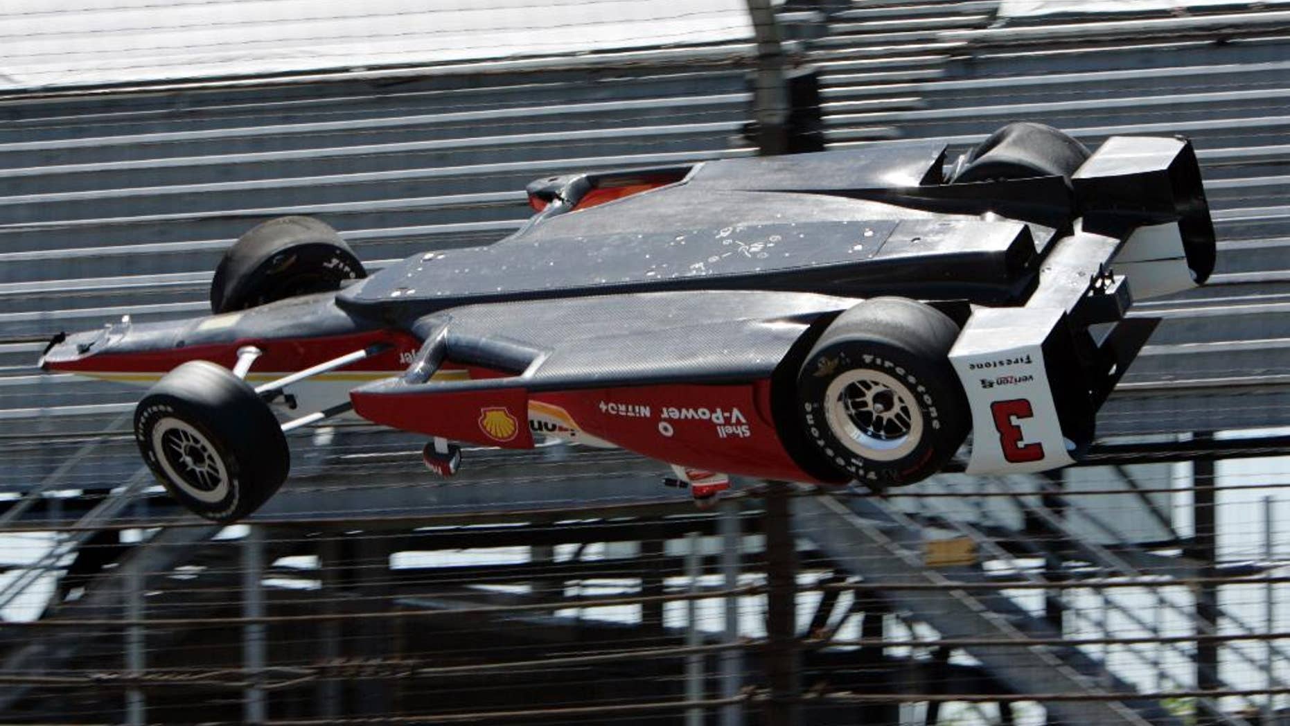 AP10ThingsToSee - The car driven by Helio Castroneves, of Brazil, is airborne after hitting a wall in the first turn during practice for the Indianapolis 500 auto race at Indianapolis Motor Speedway in Indianapolis on Wednesday, May 13, 2015. The car landed upside down before rolling onto its wheels but Castroneves was not seriously hurt. (AP Photo/Joe Watts)