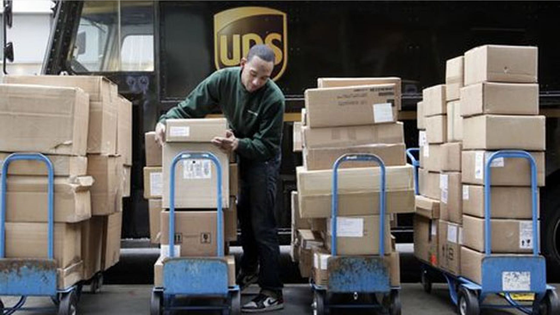 FILE- A UPS driver unloads packages from a truck (AP/FILE)