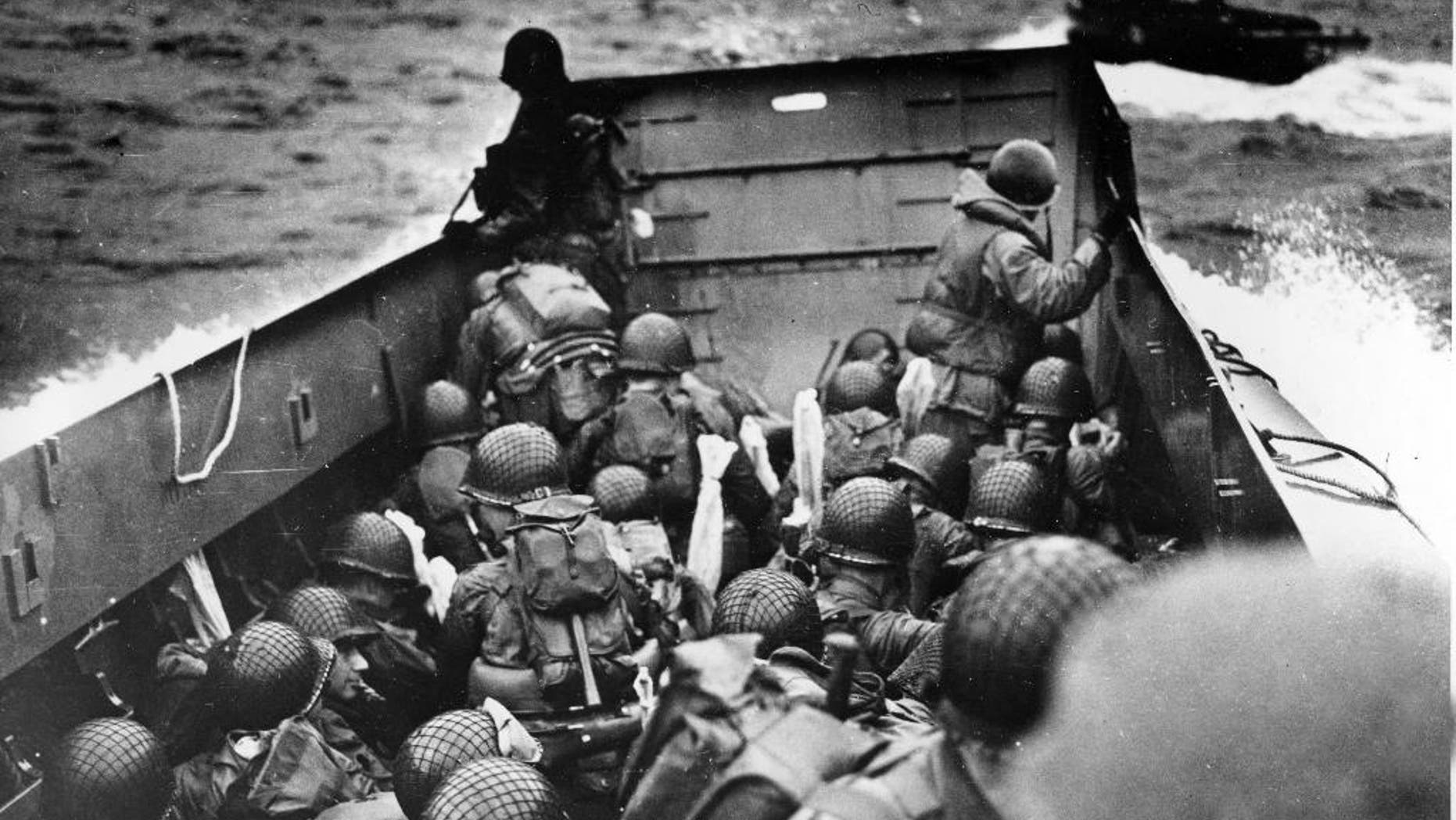 FILE - In this June 6, 2014 file photo, allied troops crouch behind the bulwarks of a landing craft as it nears Omaha Beach during a landing in Normandy, France. The D-Day invasion broke through Adolf Hitler’s western defenses and led to the liberation of France from Nazi occupation just as the Soviet Army was making advances in the east, turning the tide of the war in the Allies’ favor. Allied troops landed on the Normandy coast of France in tremendous strength by cloudy daylight today and stormed several miles inland with tanks and infantry in the grand assault which Gen. Dwight D. Eisenhower called a crusade in which “we will accept nothing less than full victory.”(AP Photo/U.S. Coast Guard, File)