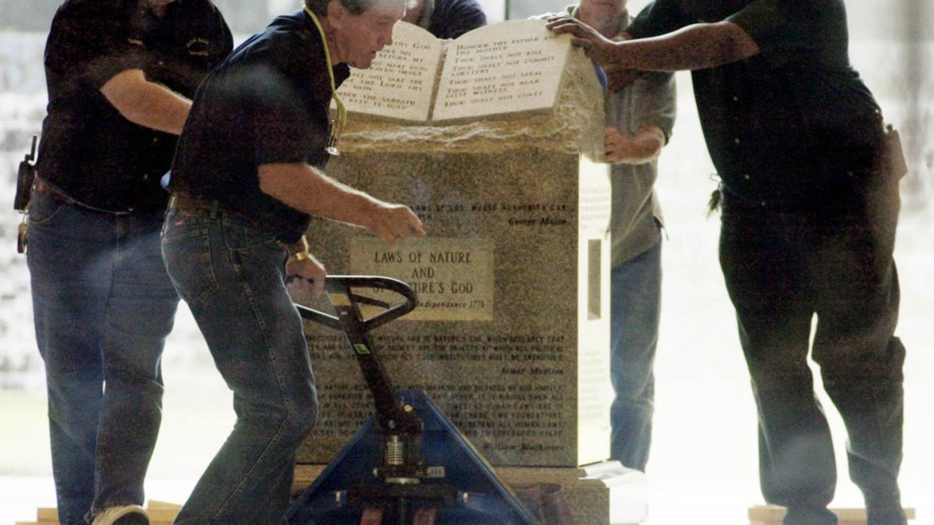 Crews remove a Ten Commandments monument from an Alabama courthouse in 2003 after judge Roy Moore was stripped of his position for refusing to take down the statue. (AP Photo/Bill Haber)