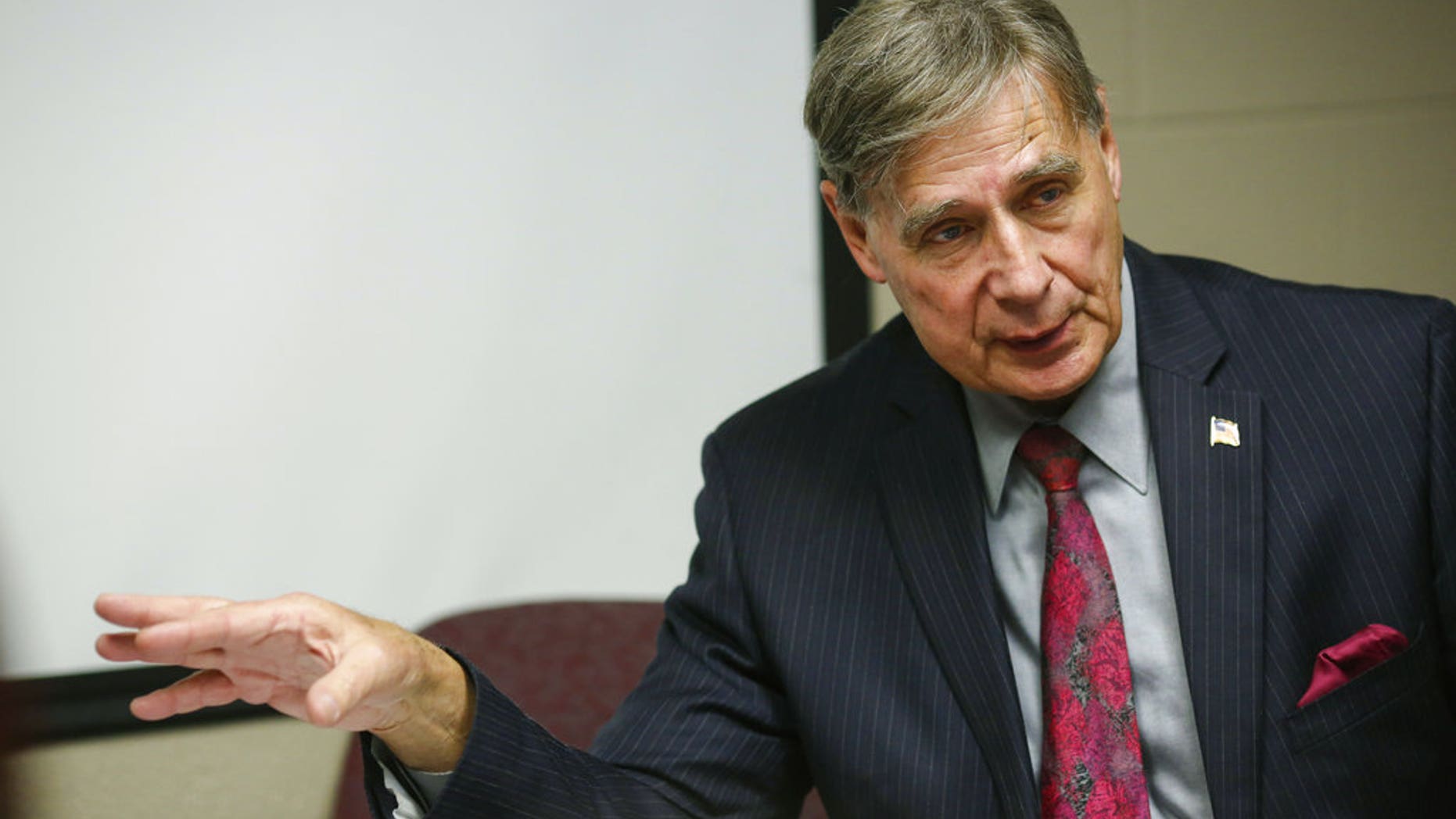 In this Wednesday, Jan. 28, 2015 photo, Director of School and Community Relations Art Wenzlaff answers questions in a conference room at International Academy in Flint, Mich. Wenzlaff, a neighborhood advocate in Flint has been charged after items reportedly were taken from a casket.