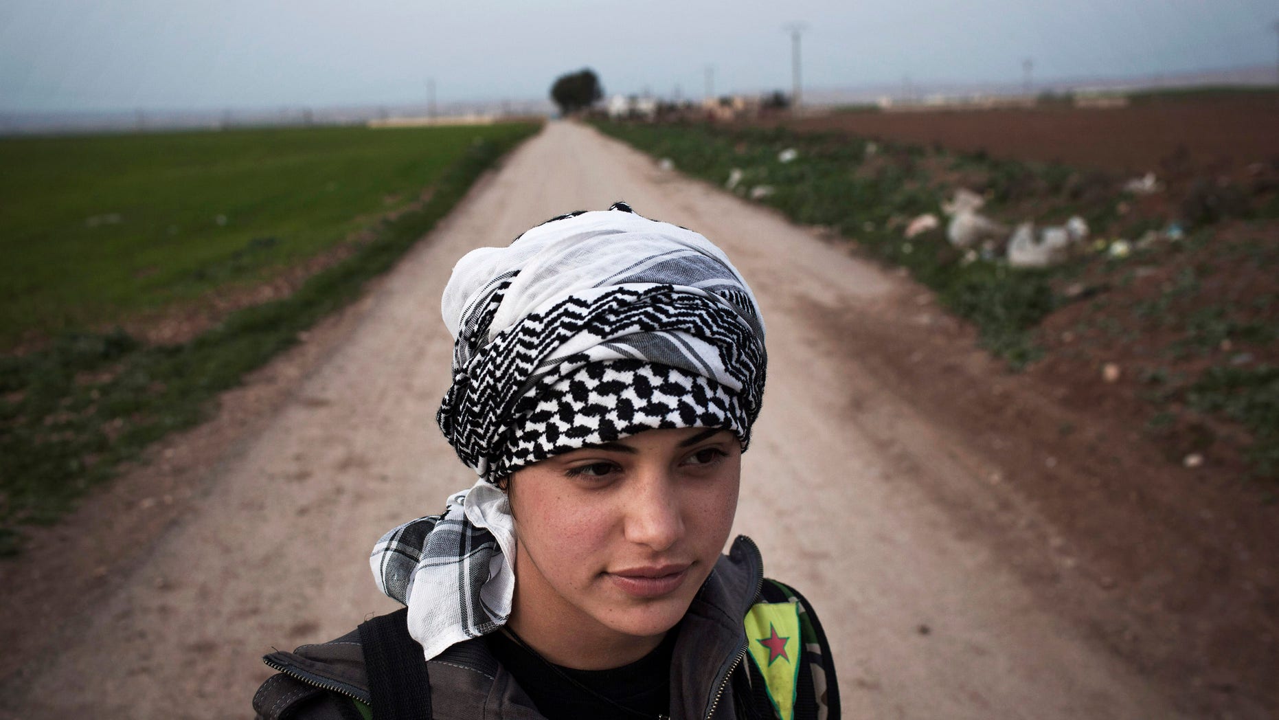 A Kurdish female member of the Popular Protection Units stands guard at a check point near the northeastern city of Qamishli, Syria, Sunday, March 3, 2013. (AP Photo/Manu Brabo)