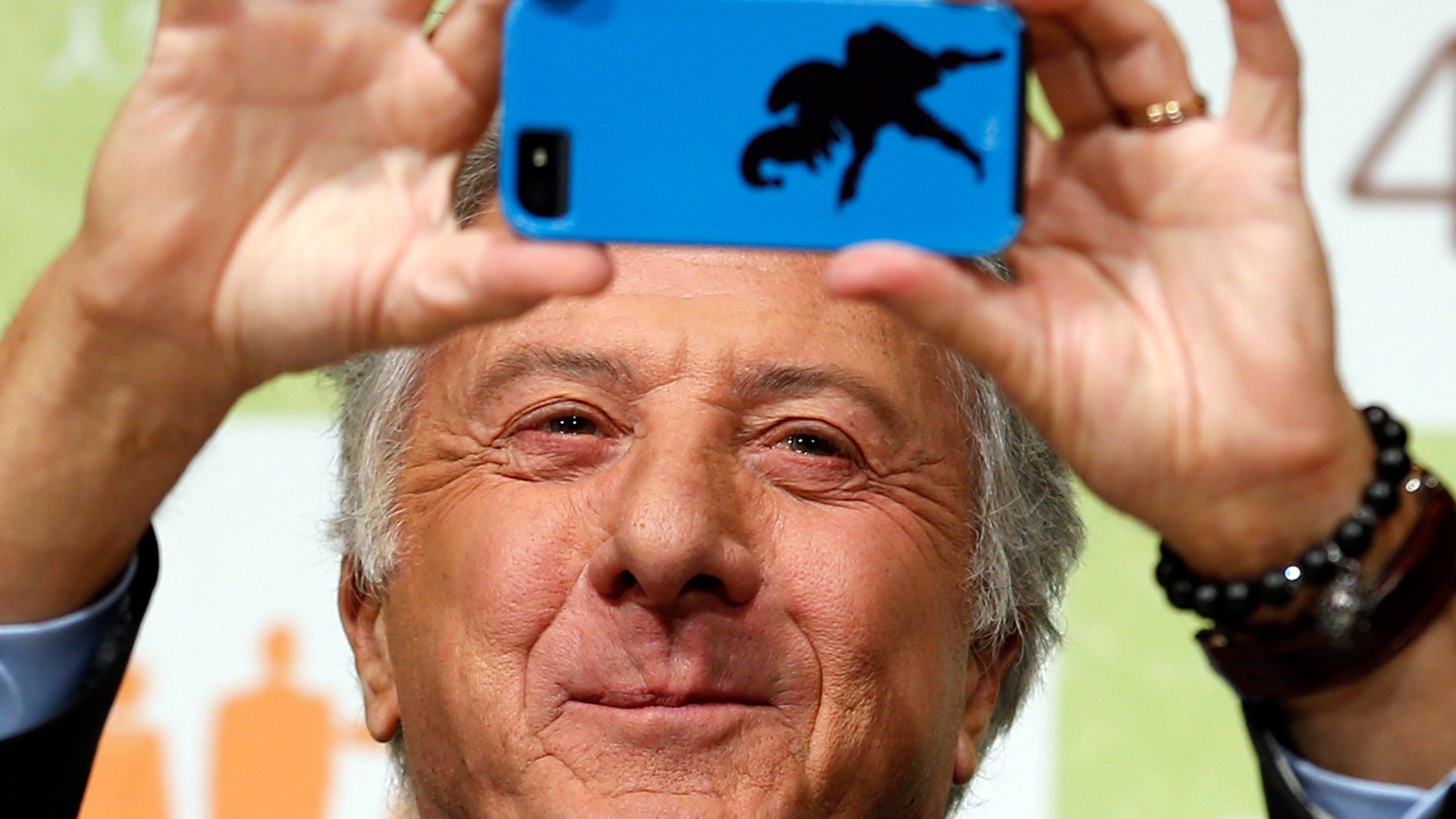 April 9, 2013: Actor Dustin Hoffman takes a photograph during a press conference to promote his film "Quartet" in Tokyo.