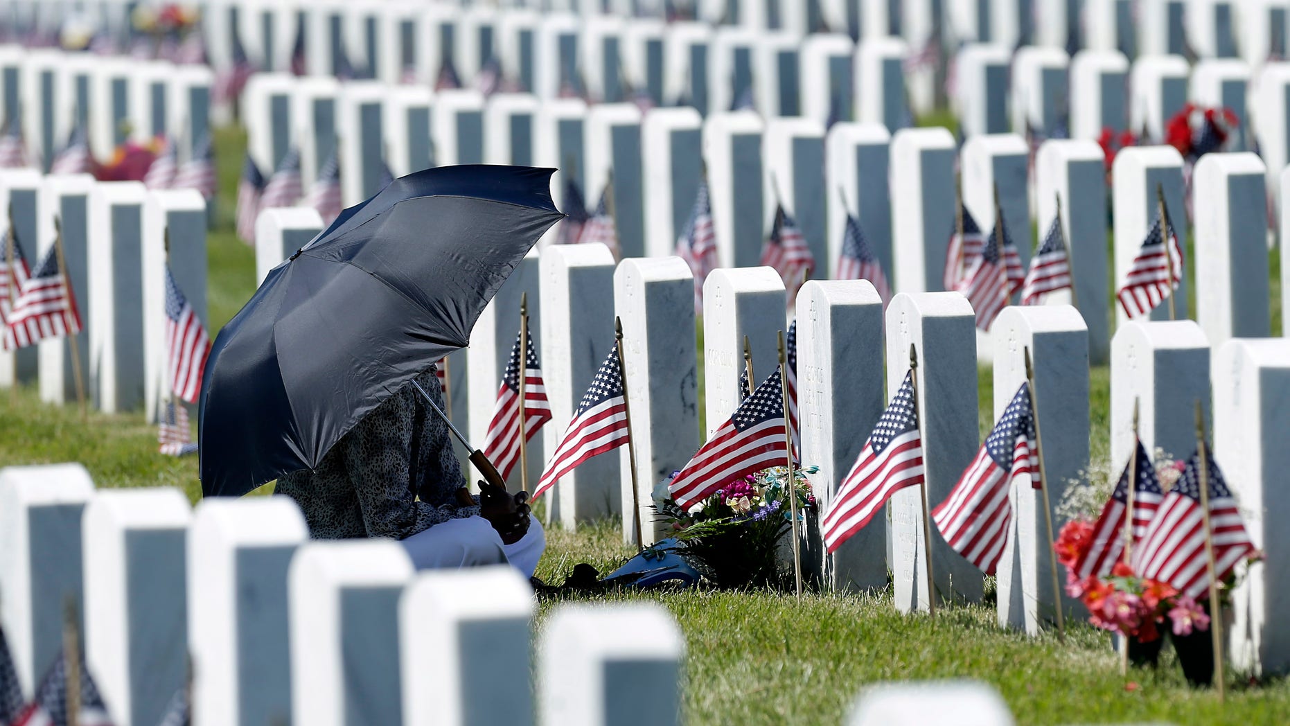 FILE -- Paulette Little visits the grave of her late husband George Little, a Navy veteran, during Memorial Day observances at the Sacramento Valley National Cemetery.