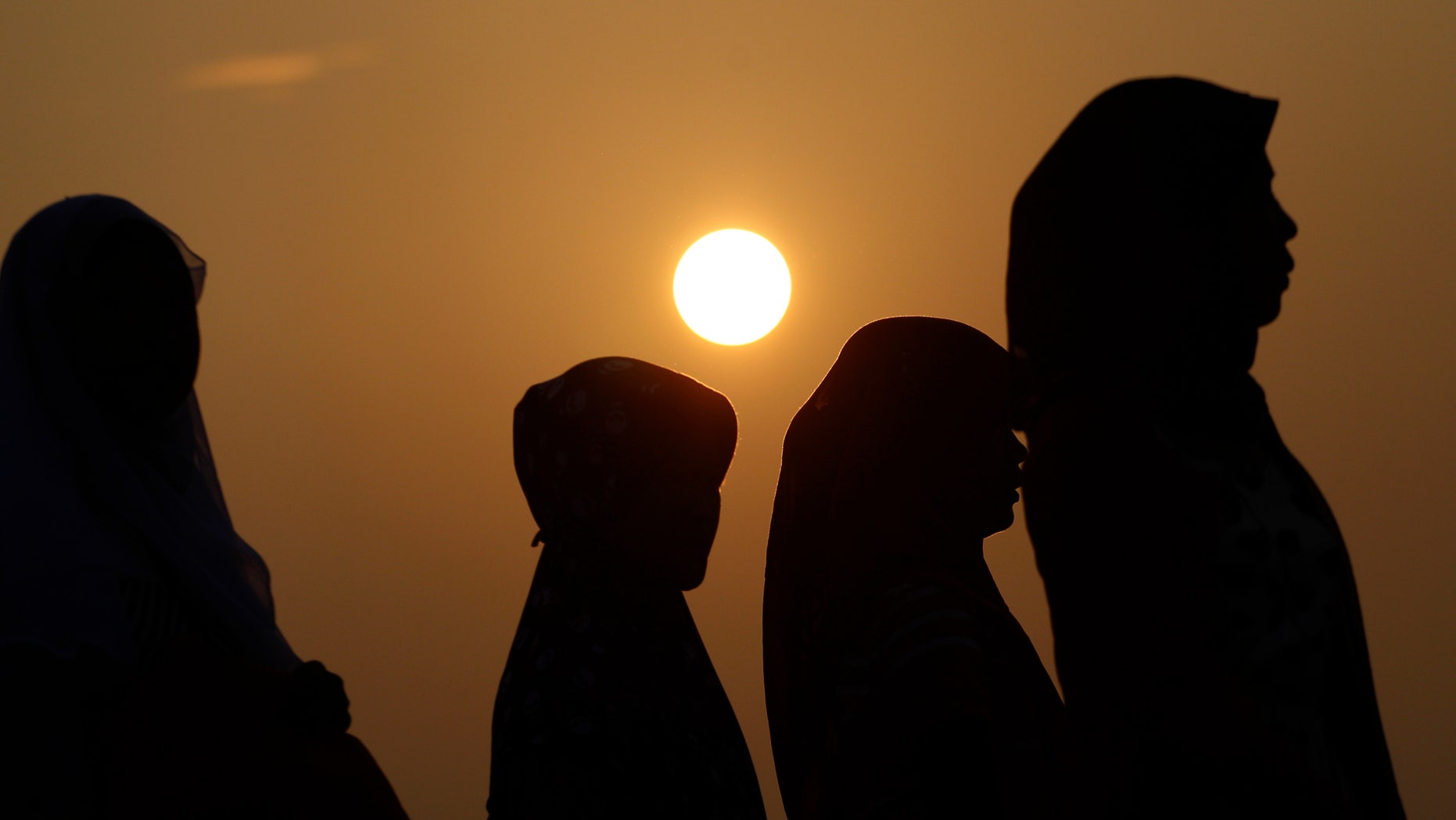 Indonesian Muslim women walk before Eid al-Fitr prayer that marks the end of the holy fasting month of Ramadan in Jakarta, Indonesia, Thursday, Aug. 8, 2013. (AP Photo/Achmad Ibrahim)