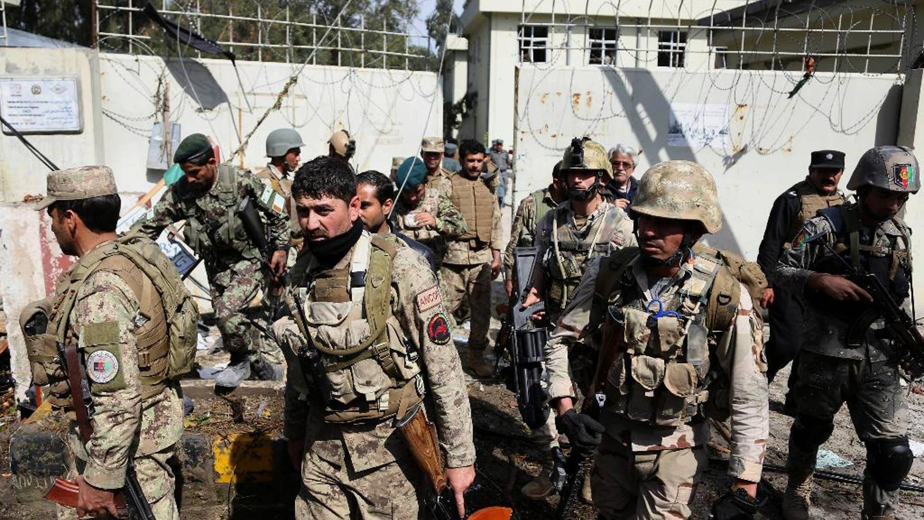 Afghan Army and police search through a police station after the Taliban staged a multi-pronged attack on a police station in Jalalabad, eastern Afghanistan, Thursday, March 20, 2014. Taliban insurgents staged the attack, using a suicide bomber and gunmen to lay siege to the station, government officials said. Two remotely detonated bombs also exploded nearby. (AP Photo/Rahmat Gul)