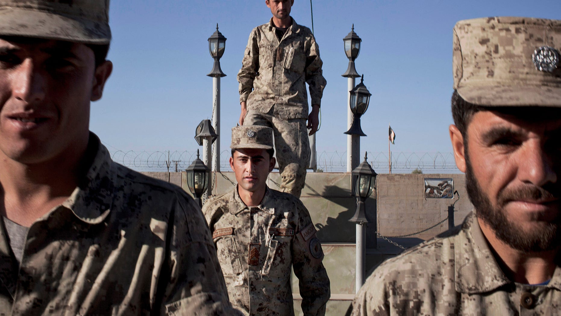 Afghan National Police line up after the official ceremony to take down the flag at the end of the day at their base in Lashkar Gah, Helmand, Afghanistan, Wednesday, Oct. 17, 2012. In eastern Afghanistan a suicide car bomber blew up his vehicle near the gate of a U.S.- Afghan combat outpost Wednesday, wounding at least 10 Afghan soldiers. (AP Photo/Anja Niedringhaus)