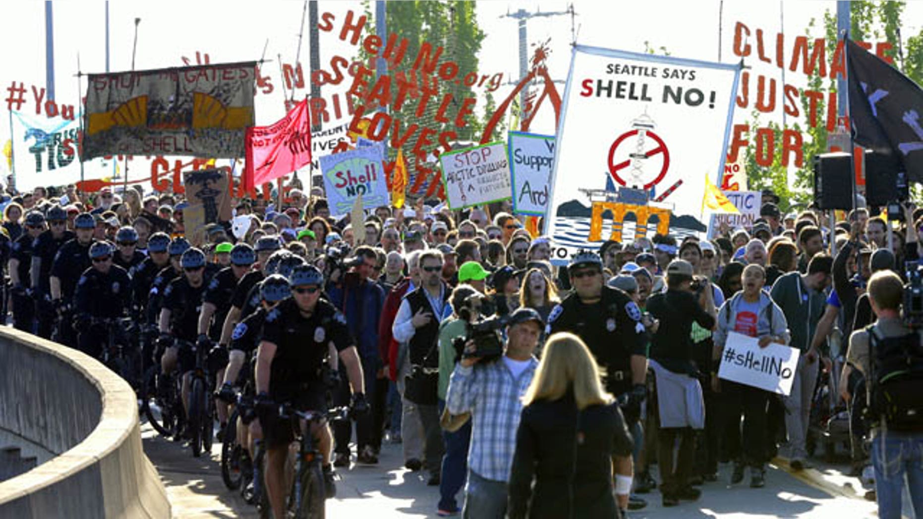 May 18, 2015: Protesters accompanied by Seattle police march at the Port of Seattle. Demonstrators opposed to Arctic oil drilling were showing opposition to a lease agreement between Royal Dutch Shell and the Port to allow some of Shell's oil drilling equipment to be based in Seattle. (AP Photo/Ted S. Warren)