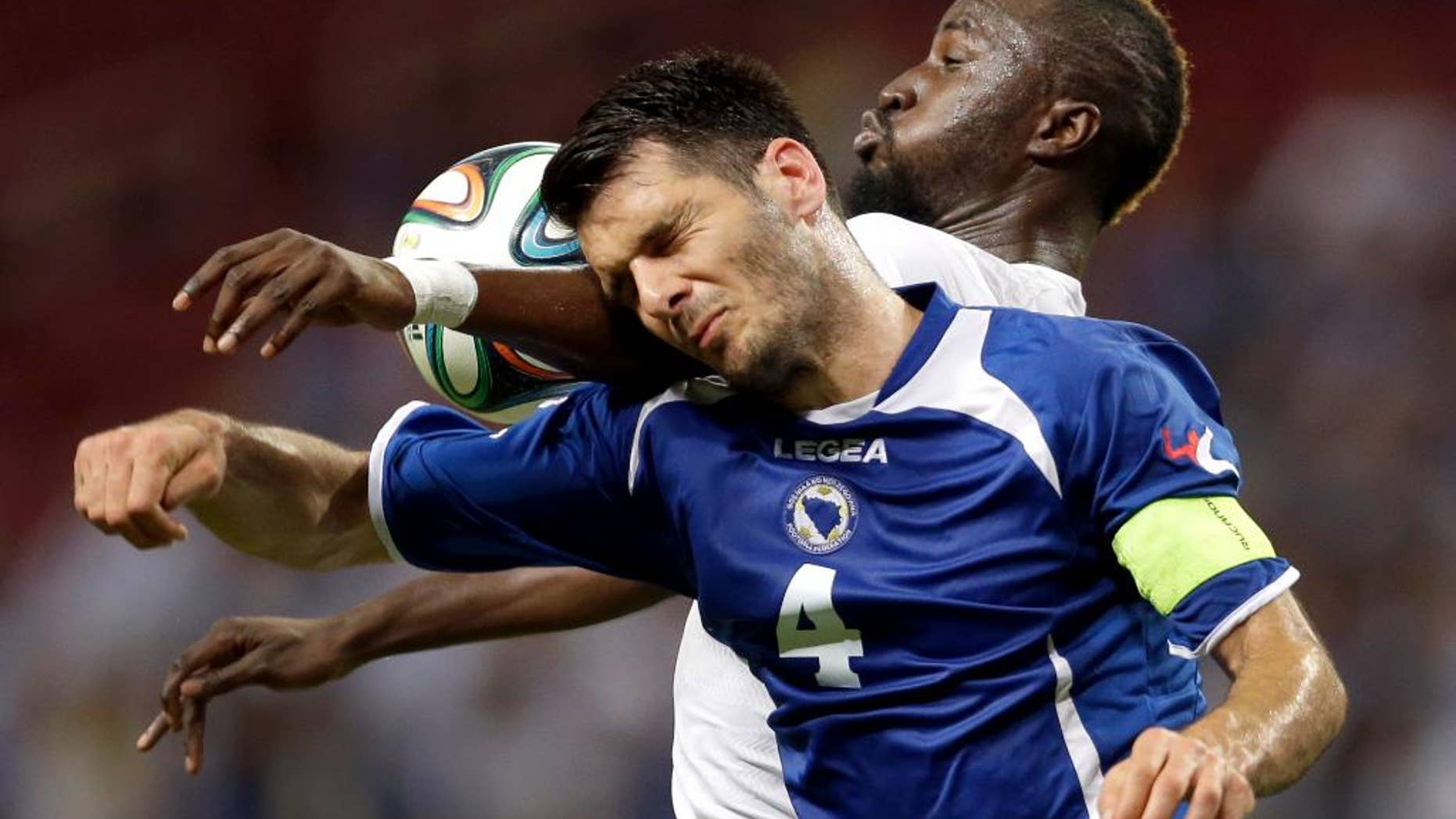 Bosnia-Herzegovina's Emir Spahic, front, and Ivory Coast's Lacina Traore vie for the ball during the first half in an international friendly soccer match Friday, May 30, 2014, in St. Louis. (AP Photo/Jeff Roberson)