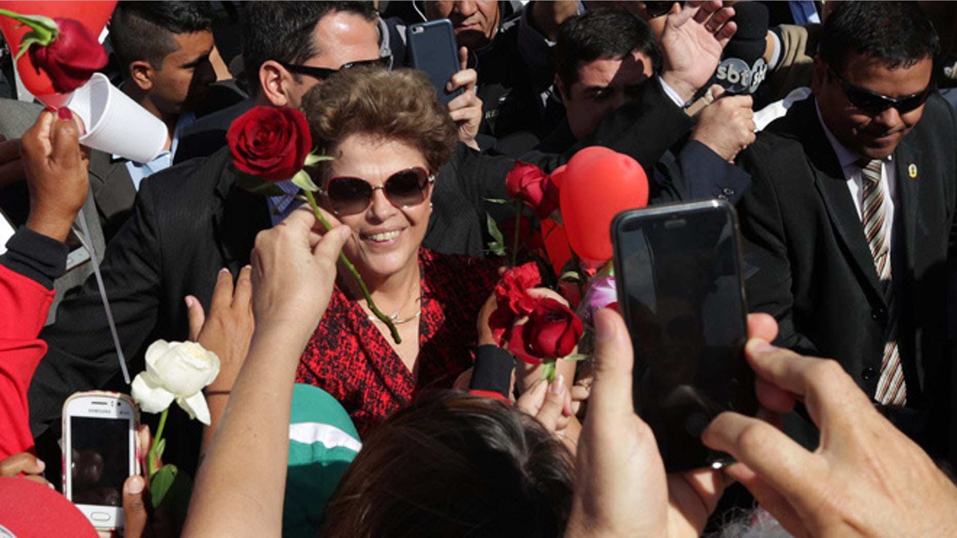 Brazil's impeached President Dilma Rousseff receives flowers from supporters as she leaves the presidential residence, on Sept. 6, 2016.