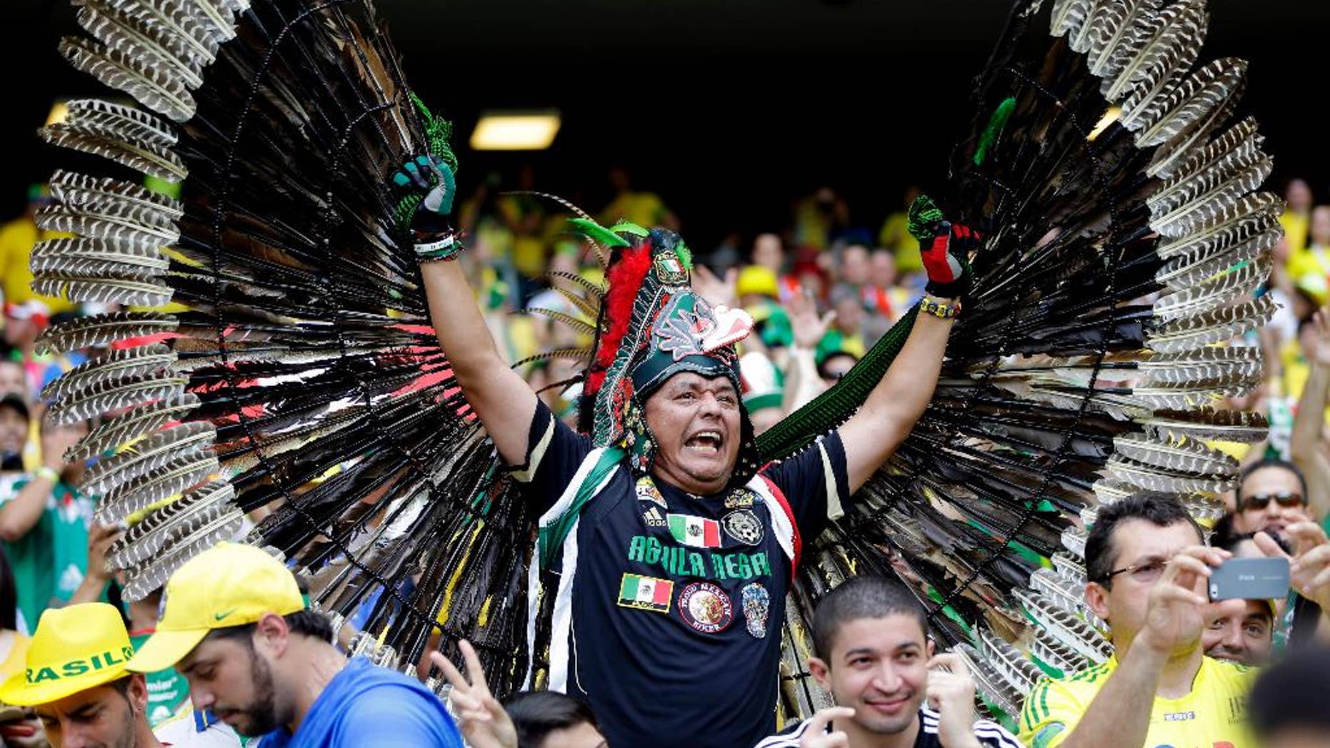 A Mexican fan shows off his costume before the group A World Cup soccer match between Brazil and Mexico at the Arena Castelao in Fortaleza, Brazil, Tuesday, June 17, 2014. (AP Photo/Andre Penner)