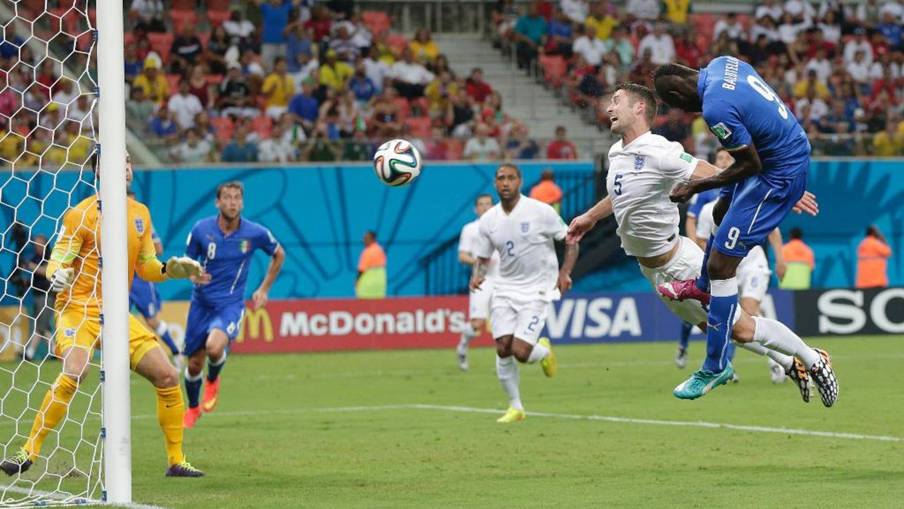 Italy's Mario Balotelli (9) heads the ball past England's Gary Cahill (5) and goalkeeper Joe Hart, left, to score Italy's second goal during the group D World Cup soccer match between England and Italy at the Arena da Amazonia in Manaus, Brazil, Saturday, June 14, 2014. (AP Photo/Marcio Jose Sanchez)