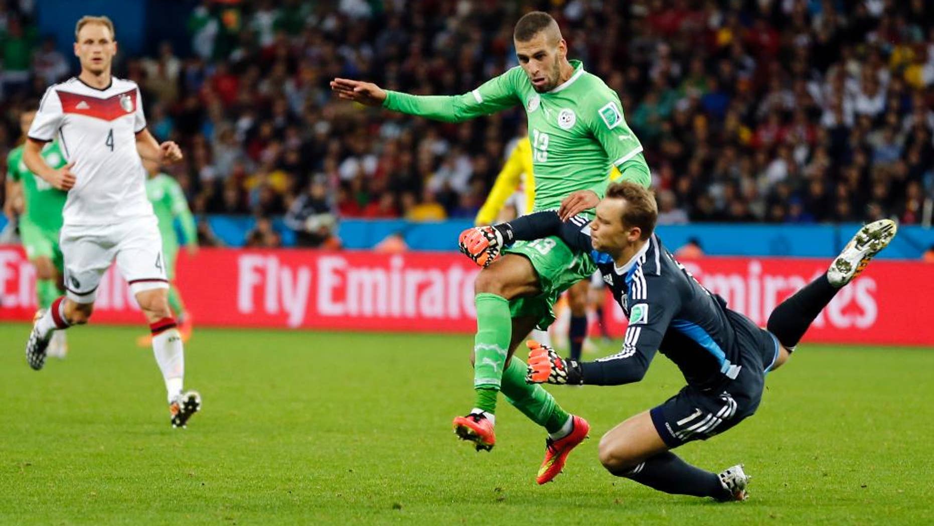 Germany's goalkeeper Manuel Neuer, right, clears the ball from Algeria's Islam Slimani during the World Cup round of 16 soccer match between Germany and Algeria at the Estadio Beira-Rio in Porto Alegre, Brazil, Monday, June 30, 2014. (AP Photo/Frank Augstein)