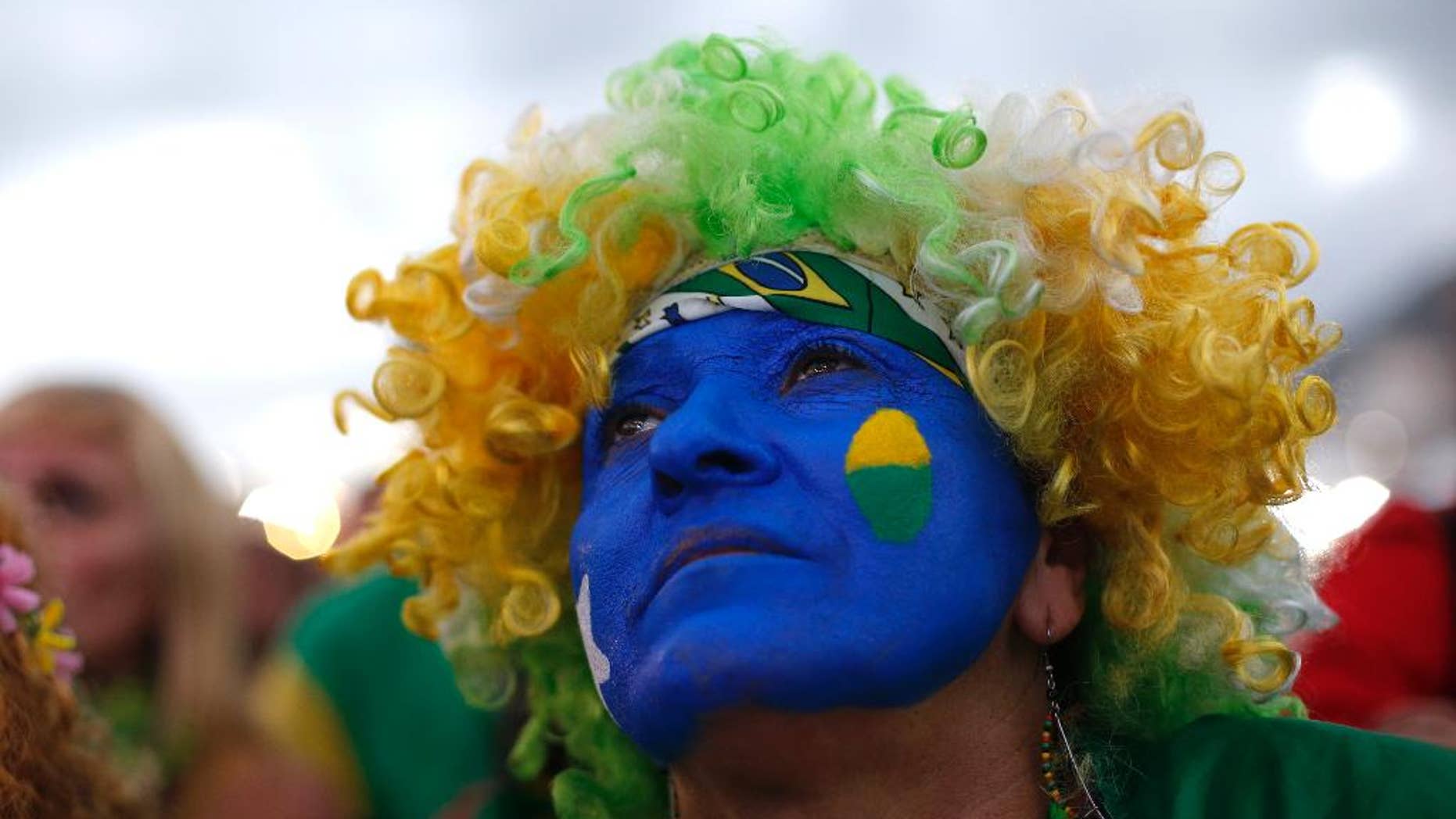 A fan of the Brazil national soccer team watches a live broadcast of the World Cup third-place soccer match between Brazil and Netherlands, inside the FIFA Fan Fest area on Copacabana beach, in Rio de Janeiro, Brazil, Saturday, July 12, 2014. (AP Photo/Silvia Izquierdo)