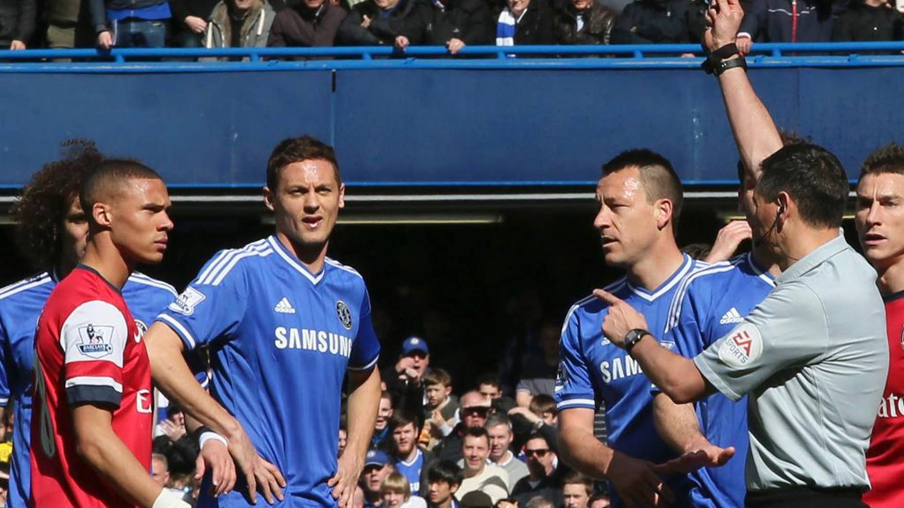Referee Andre Marriner, in grey, sends off Arsenal's Kieran Gibbs, left, during their English Premier League soccer match between Chelsea and Arsenal at Stamford Bridge stadium in London Saturday, Mar 22 2014. (AP Photo/Alastair Grant)