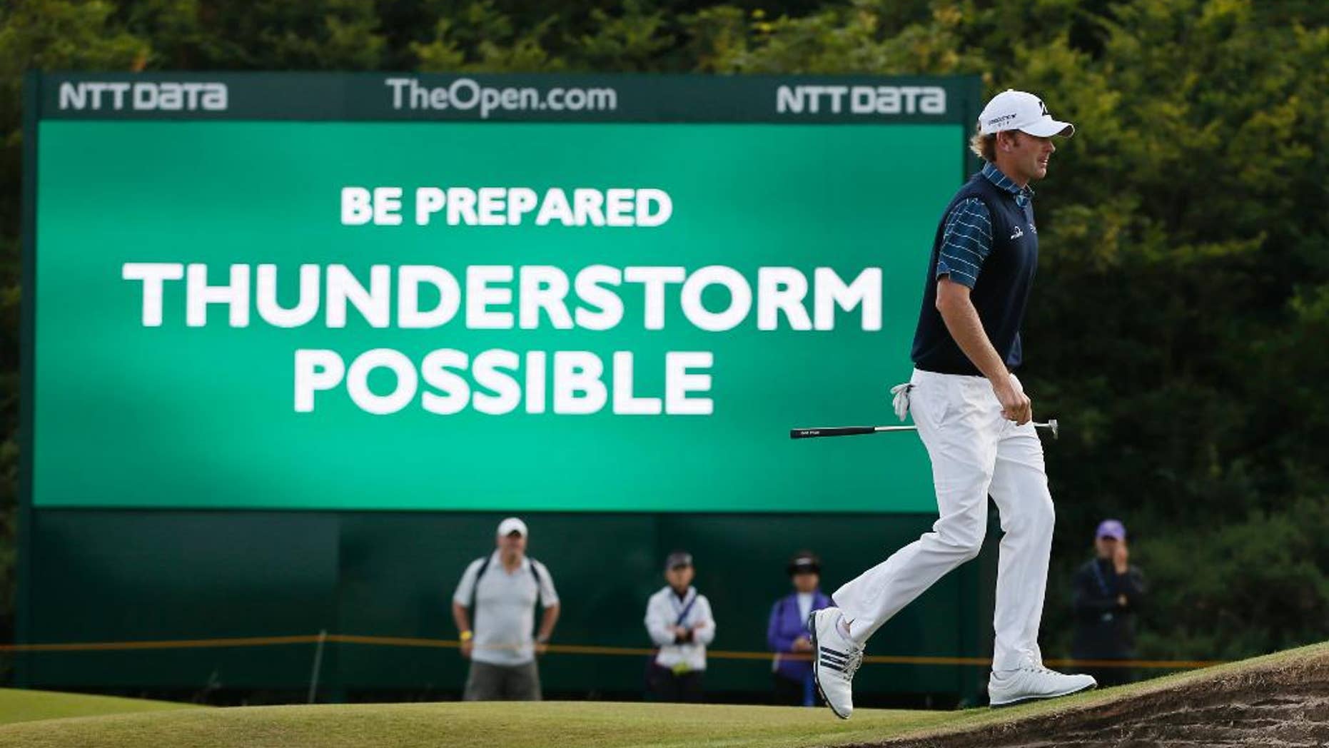 Brandt Snedeker of the US walks past a digital sign showing a weather warning on the second day of the British Open Golf championship at the Royal Liverpool golf club, Hoylake, England, Friday July 18, 2014. (AP Photo/Alastair Grant)
