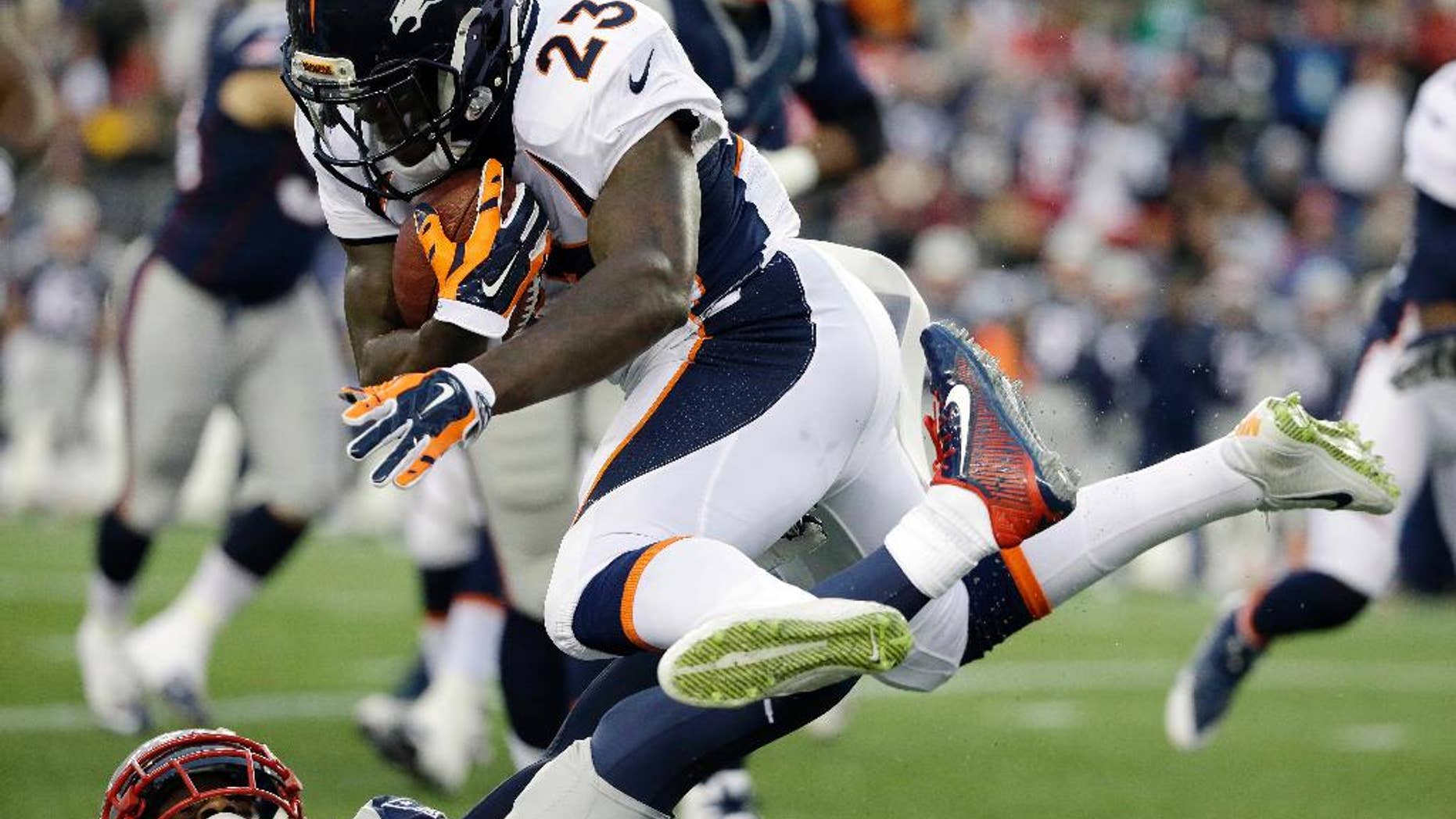 Denver Broncos running back Ronnie Hillman (23) leaps over a New England Patriots defender in the first half of an NFL football game on Sunday, Nov. 2, 2014, in Foxborough, Mass. (AP Photo/Steven Senne)