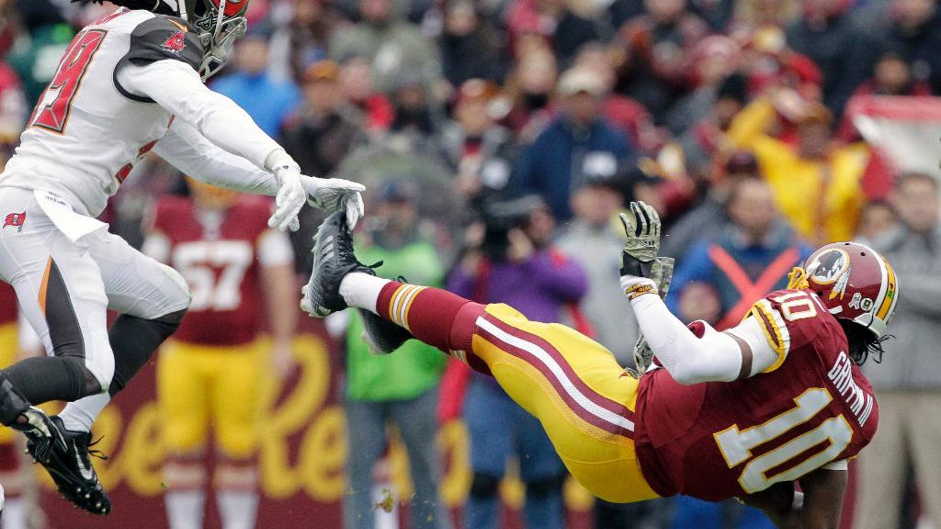 Tampa Bay Buccaneers defensive back Brandon Dixon (39) knocks down Washington Redskins quarterback Robert Griffin III (10) during the first half of an NFL football game in Landover, Md., Sunday, Nov. 16, 2014. (AP Photo/Mark Tenally)