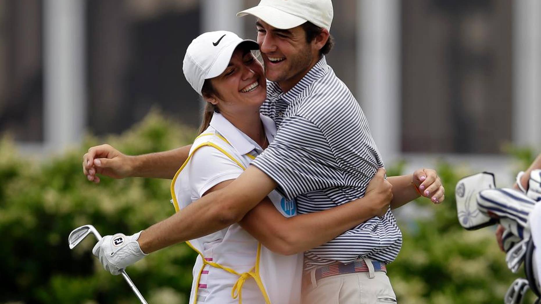 Scottie Scheffler, 17, of Highland Park High School in Dallas, is hugged by his sister Callie, who is his caddie, after Scheffler sunk a hole-in-one on a 218-yard second hole during the third round of the Byron Nelson Championship golf tournament, Saturday, May 17, 2014, in Irving, Texas. Scheffler is playing in the tournament on a sponsor execption. (AP Photo/Tony Gutierrez)