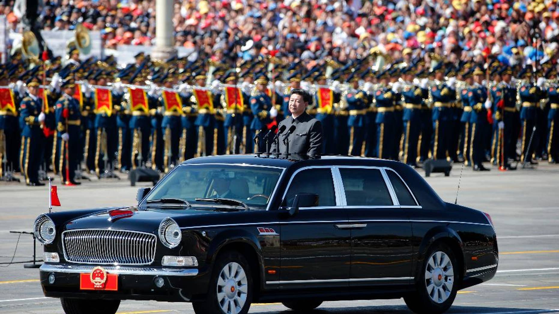 Chinese President Xi Jinping stands in a car to review the army during a parade commemorating the 70th anniversary of Japan's surrender during World War II held in front of Tiananmen Gate in Beijing, Thursday, Sept. 3, 2015. The spectacle involved more than 12,000 troops, 500 pieces of military hardware and 200 aircraft of various types, representing what military officials say is the Chinese military's most cutting-edge technology. (AP Photo/Ng Han Guan)