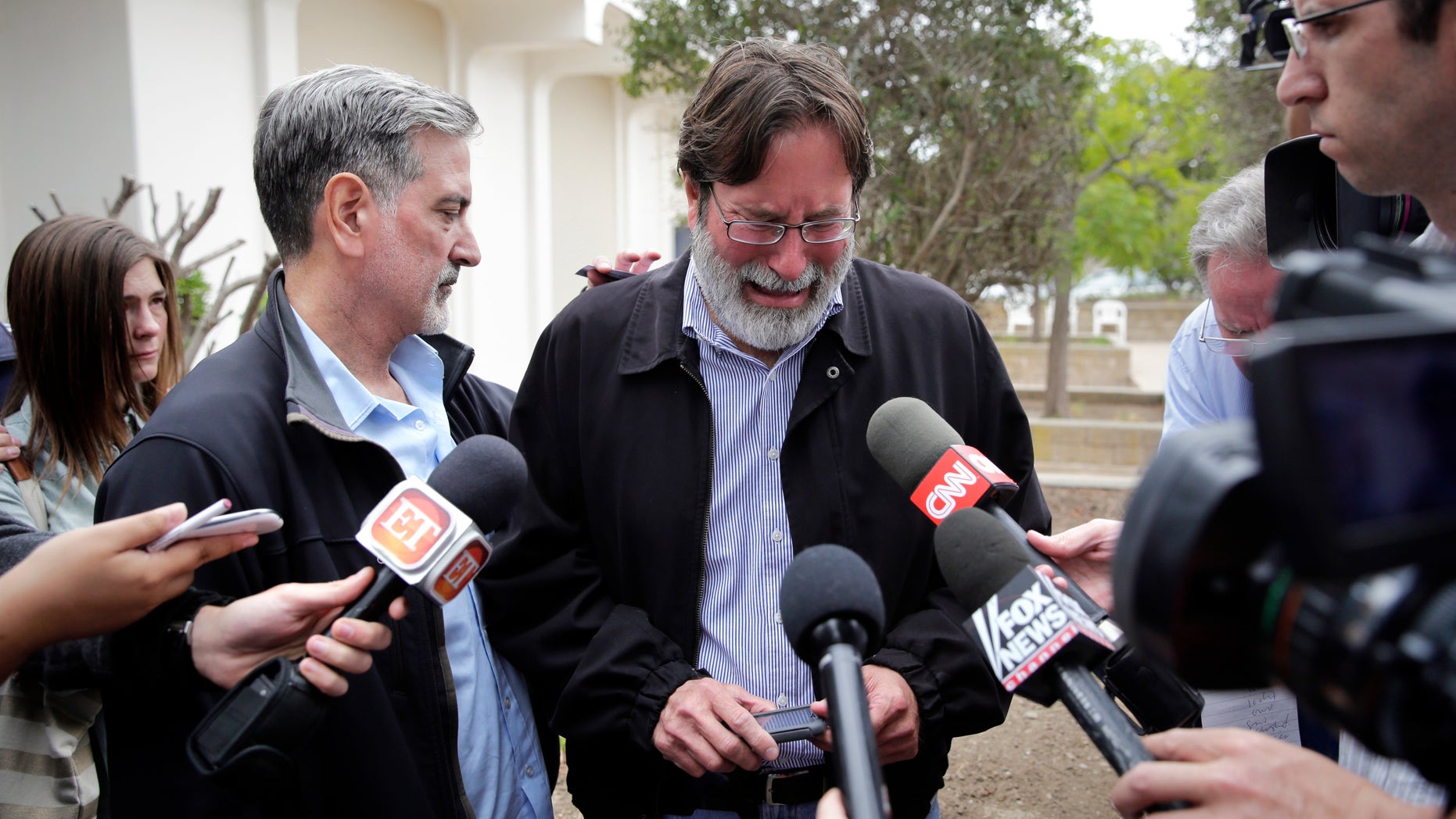 Richard Martinez is comforted by his brother Alan on Saturday, May 24, 2014, in Santa Barbara, Calif.