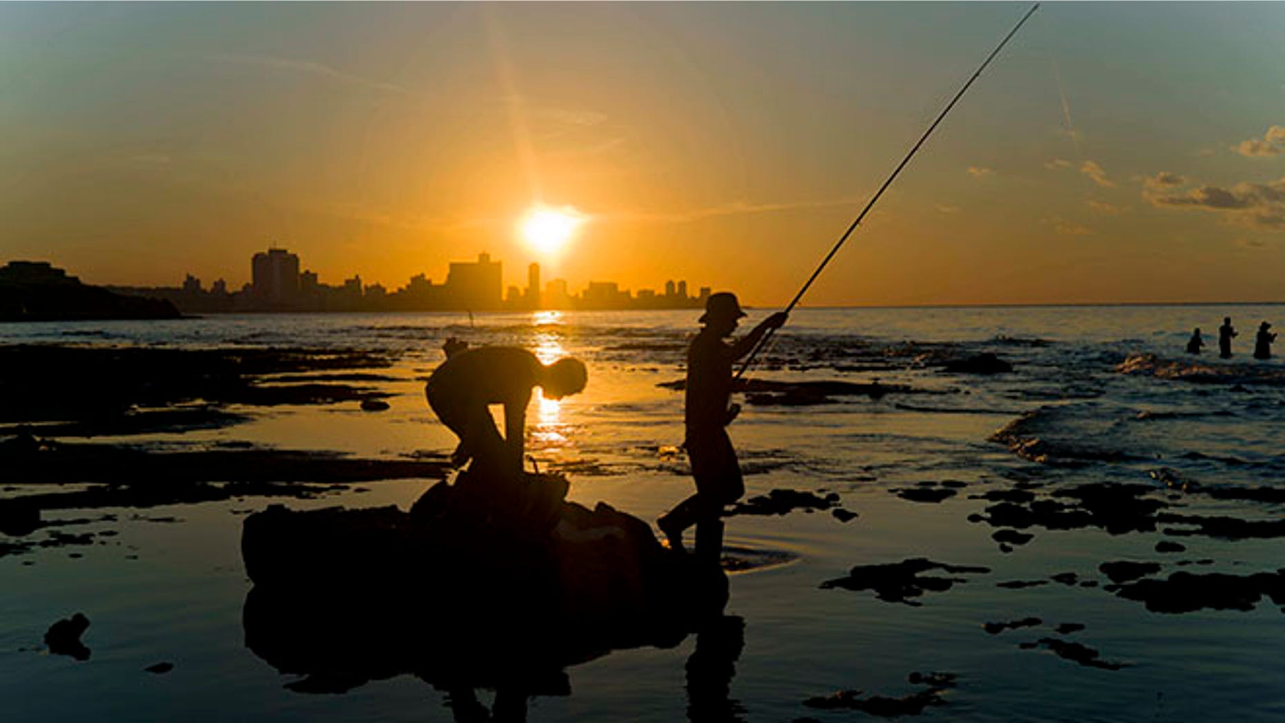 In this Nov. 11, 2016 photo, fishermen throw their fishing rods from Chivo beach as the sun sets in Havana, Cuba. Cuba has been renowned for its fishing at least since the days of Ernest Hemingway, and foreigners by the thousands come each year to fish in waters largely protected by Cubaâs lack of development. (AP Photo/Ramon Espinosa)