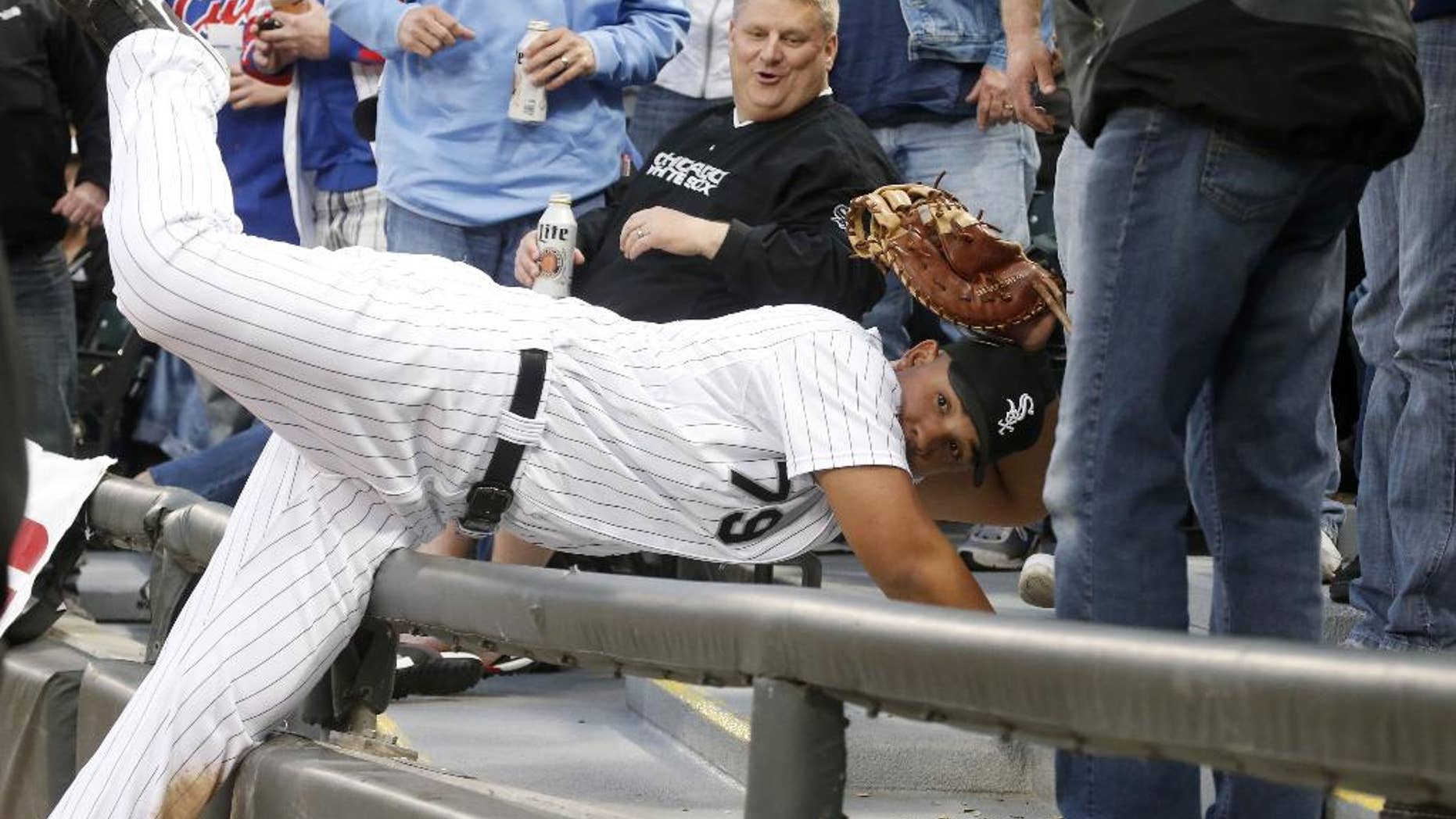 Chicago White Sox first baseman Jose Abreu shows his glove to first base umpire Marvin Hudson, after catching a fly ball off the bat of Chicago Cubs' Darwin Barney in the seats, during the second inning of an interleague baseball game Wednesday, May 7, 2014, in Chicago. (AP Photo/Charles Rex Arbogast)